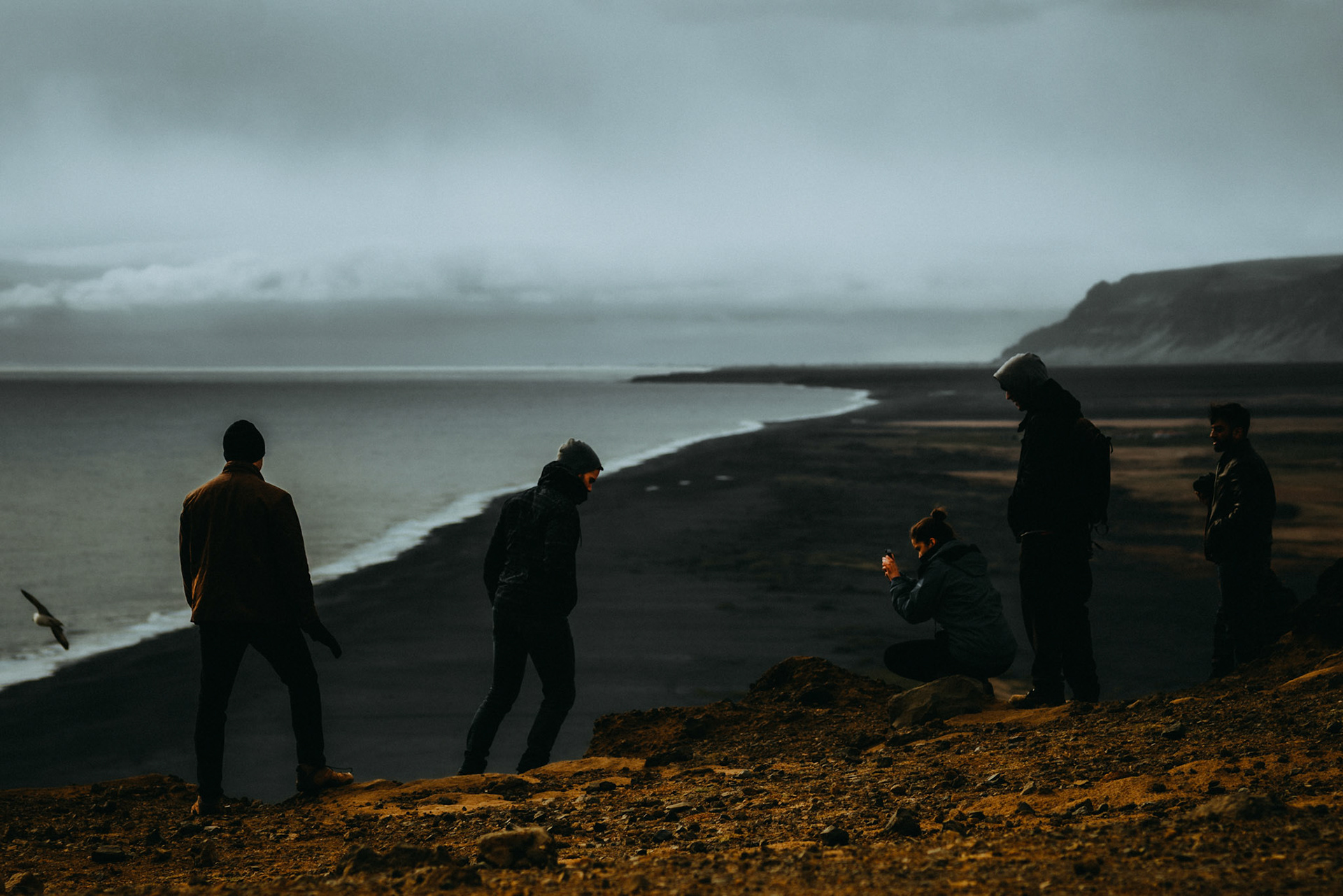 Tourists taking photos on a ridge at the Dyrhólaey Viewpoint, Iceland, May 2016, Sony A7RII.