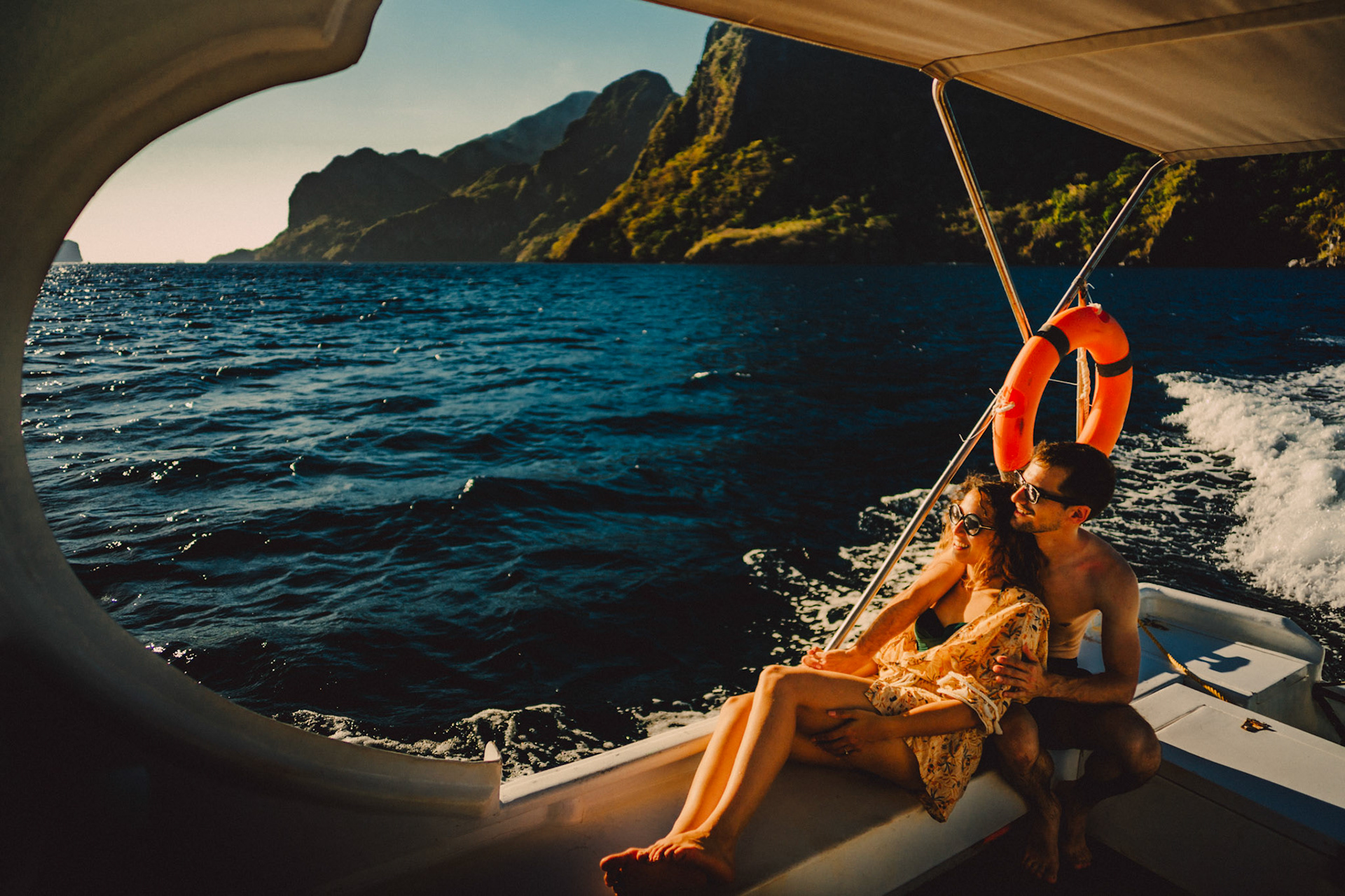 Travel couple portraits on a speed boat during an island hopping tour in Bacuit Bay, with Cadlao Island in the background, El Nido, Palawan, Philippines, Southeast Asia, April 2019, Sony A7III.