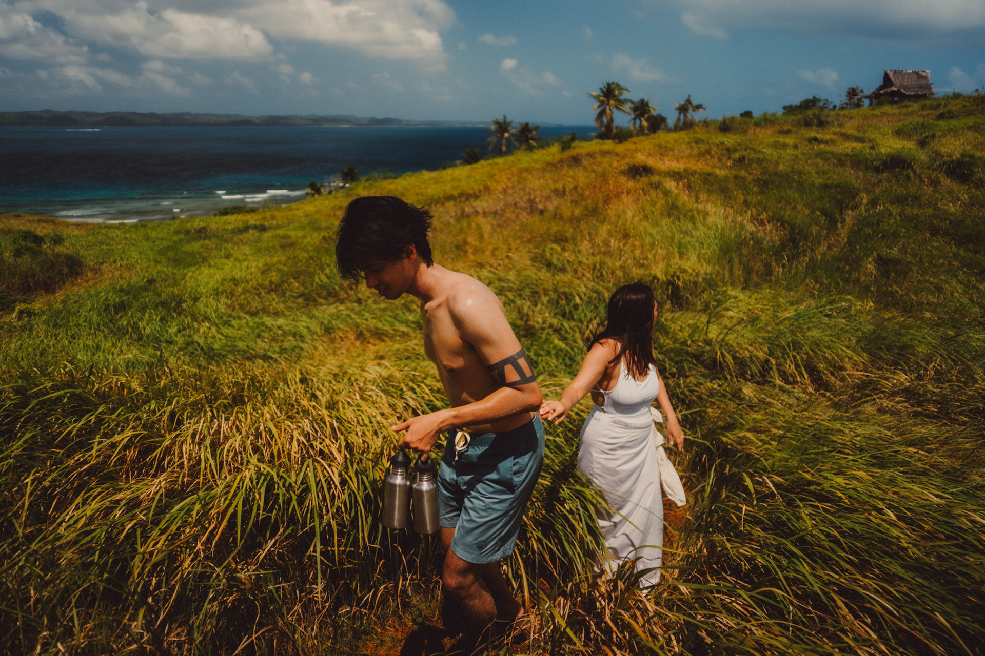 Adventure newlywed portraits with Corregidor Island's palm trees and tall cogon grass, from Jeo and Bianca's island hopping honeymoon couple portrait shoot in Surigao del Norte, Philippines, Southeast Asia, February 2020, Sony A7III