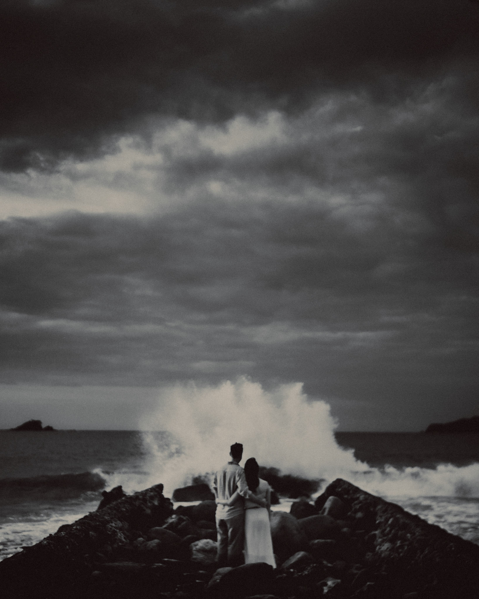 Moody black and white engagement portraits in front of crashing waves in Nacpan Beach, El Nido, Palawan, Philippines, Southeast Asia, January 2017, Leica M
