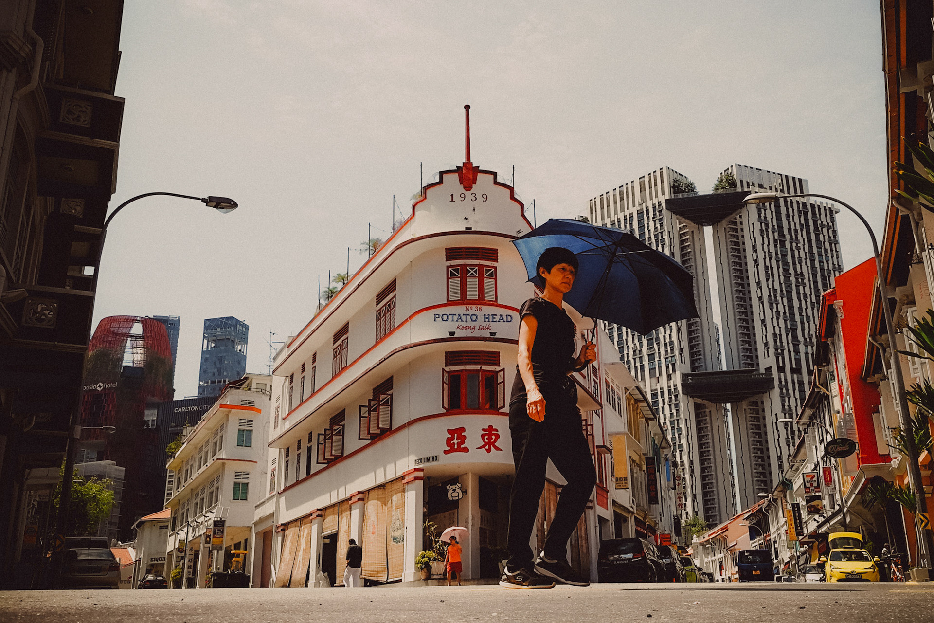 A woman holding an umbrella, walking in front of Potato Head Folk, Keong Saik Road, Singapore, October 2017, Huawei Mate 9 Pro.