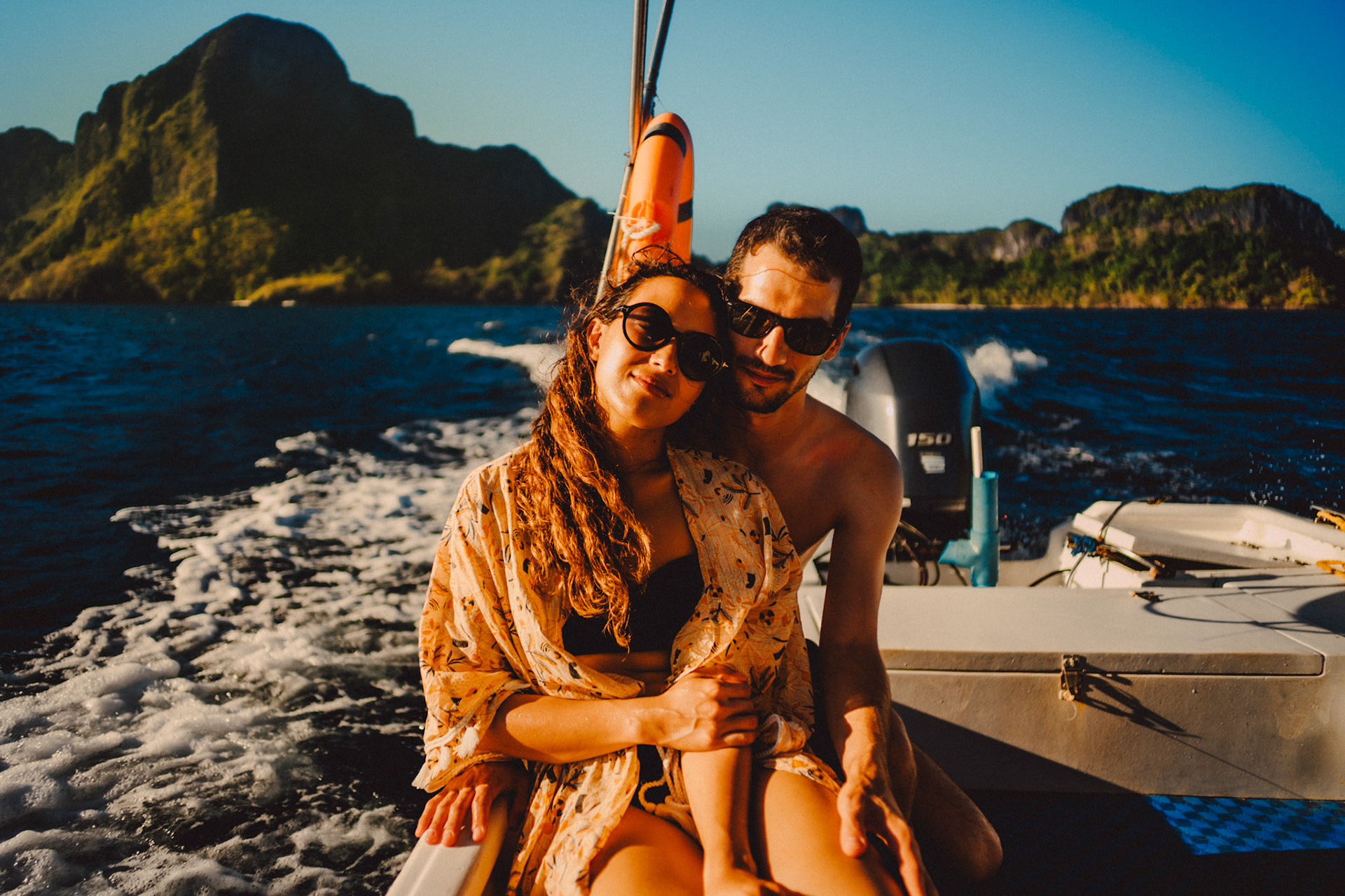 Travel couple portraits on a speed boat during an island hopping tour in Bacuit Bay, with Cadlao Island in the background, El Nido, Palawan, Philippines, Southeast Asia, April 2019, Sony A7III.