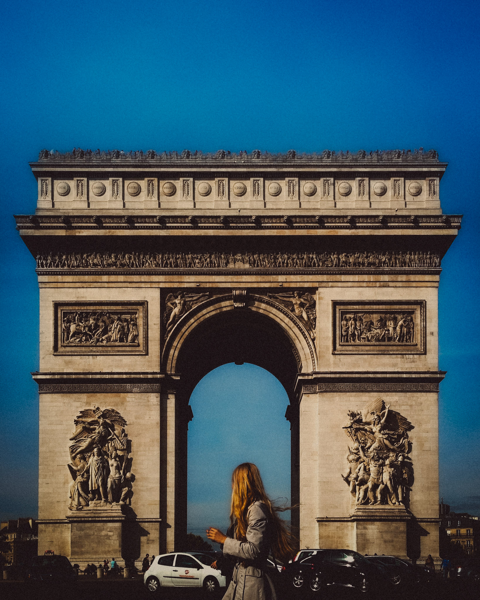 A woman with long blonde hair in front of the Arc de Triomphe, Paris, France, October 2013, Apple iPhone 5.