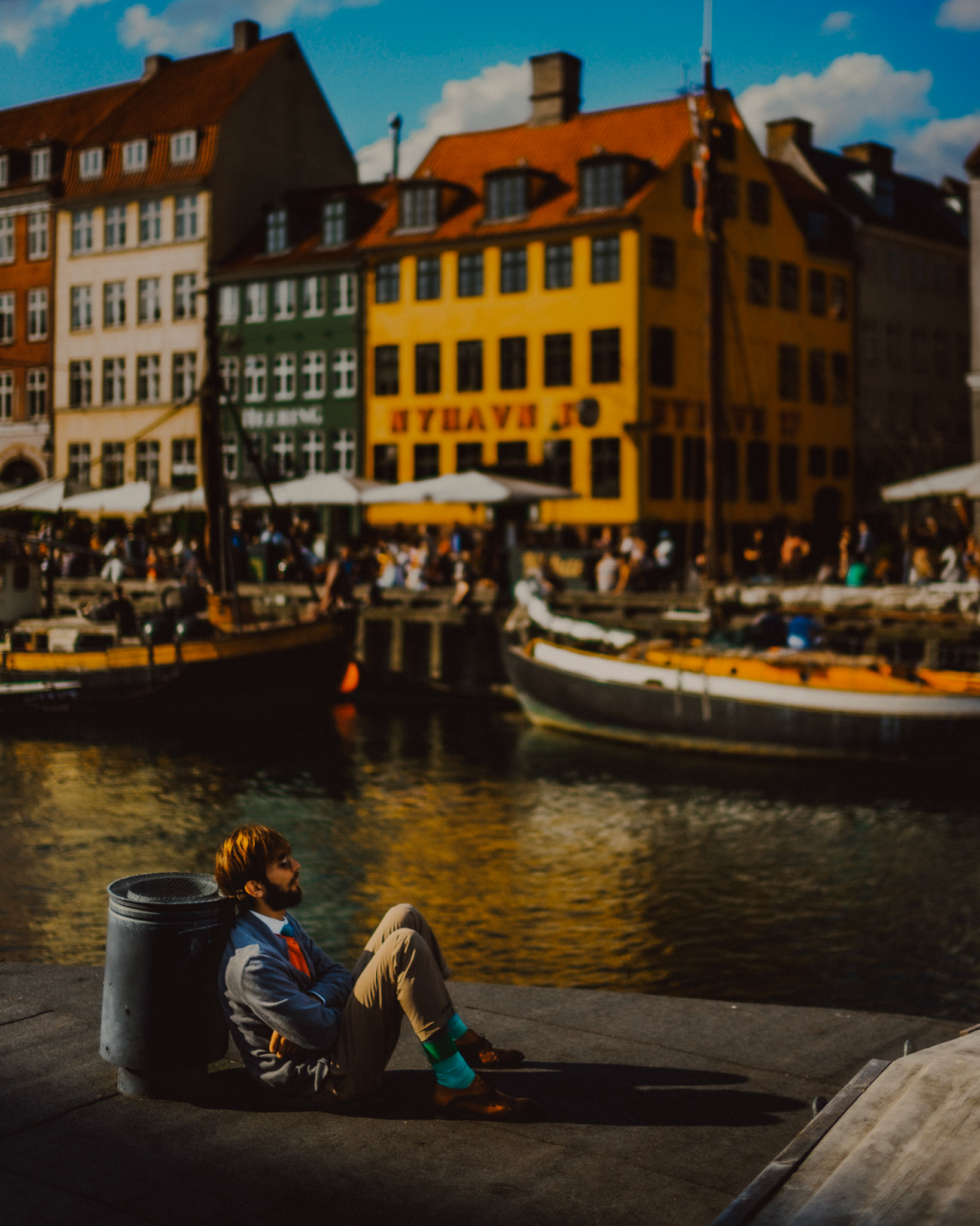 A man wearing colored socks, sitting on a moored boat in Nyhavn, Copenhagen, Denmark, August 2017, Leica M.