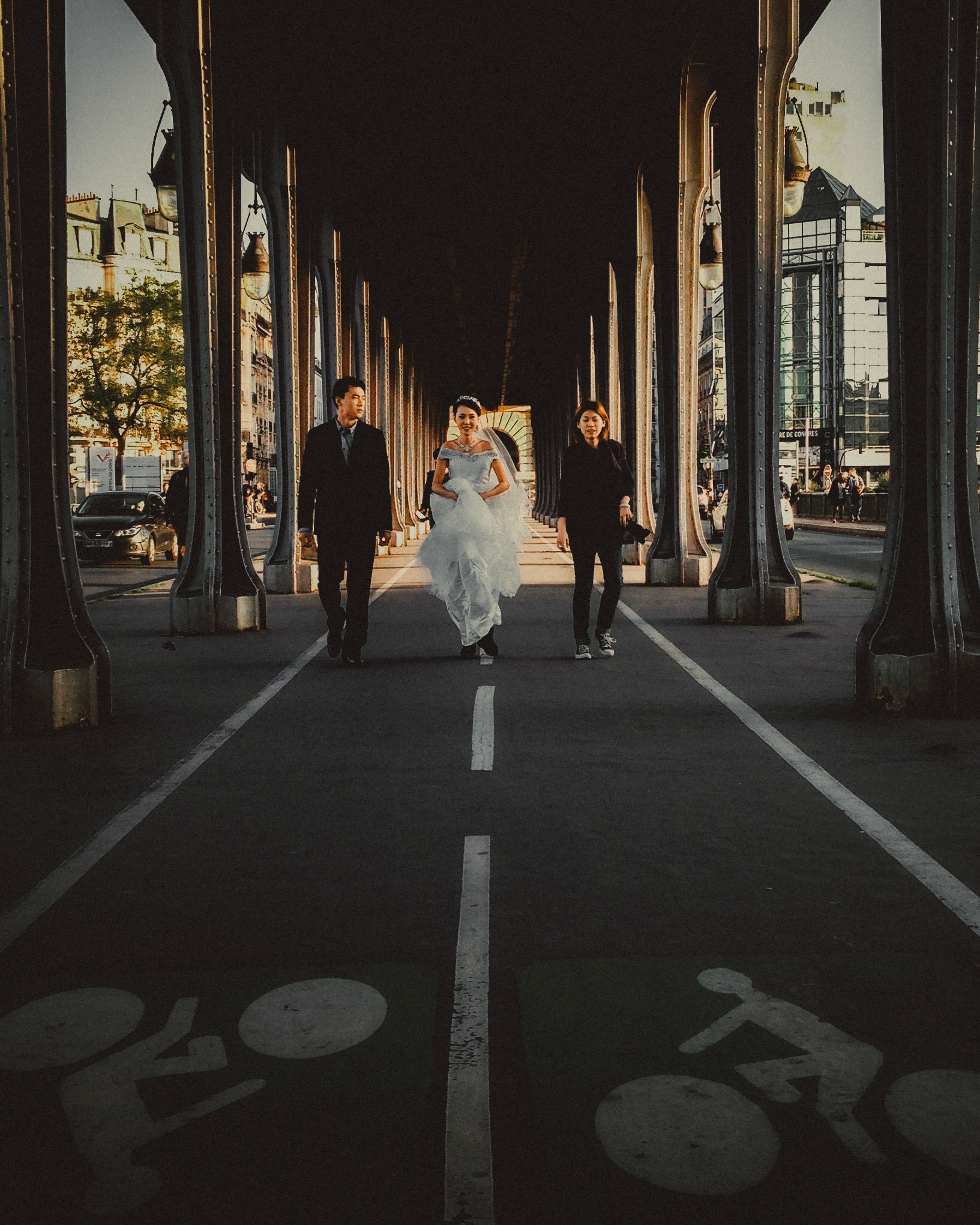 An Asian couple walking with their wedding photographer, Pont de Bir-Hakeim, Paris, France, October 2013, Apple iPhone 5.