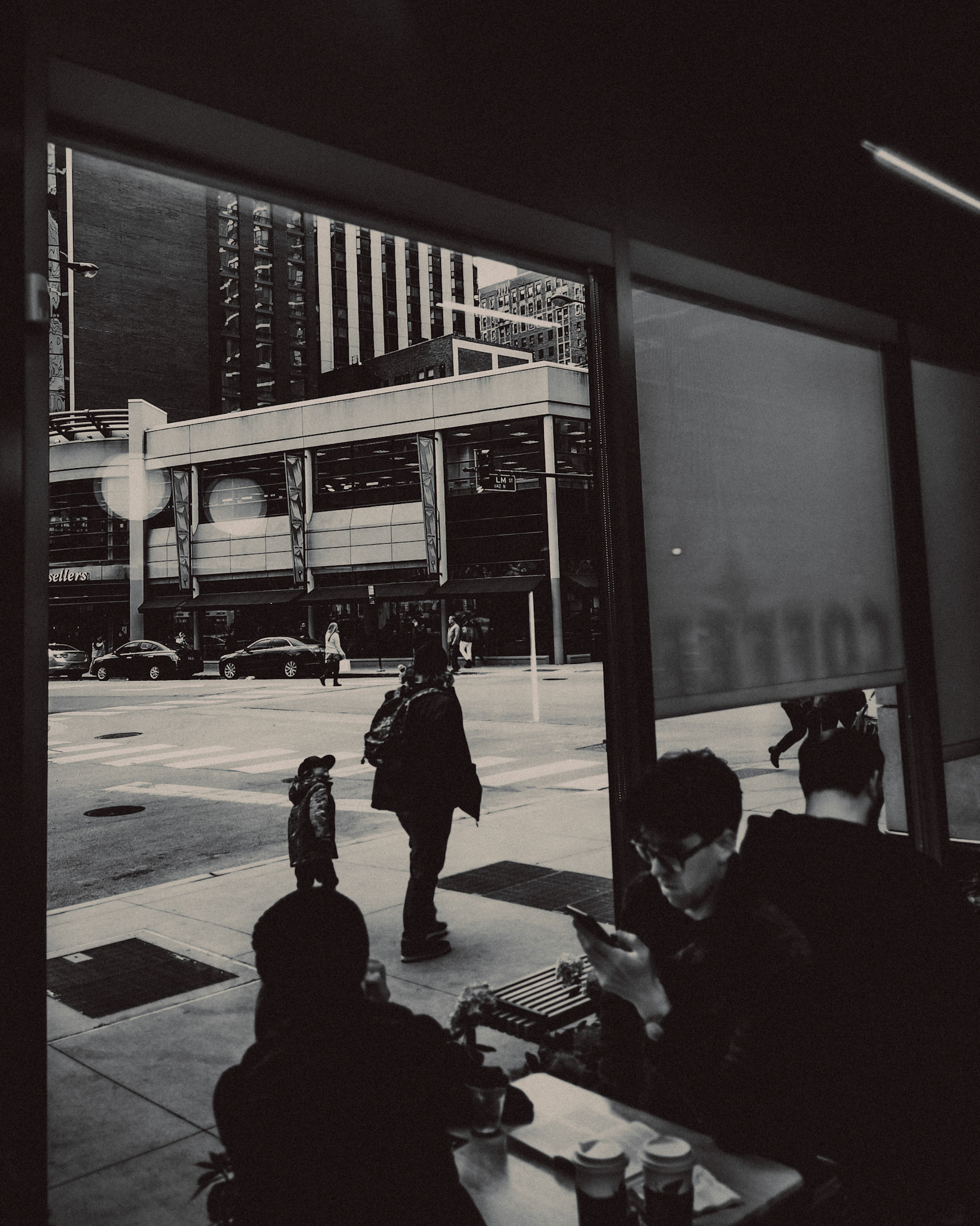 A father and his son, walking outside La Colombe Coffee Roasters, in black and white, Chicago, Illinois, USA, November 2019, Huawei P30 Pro.