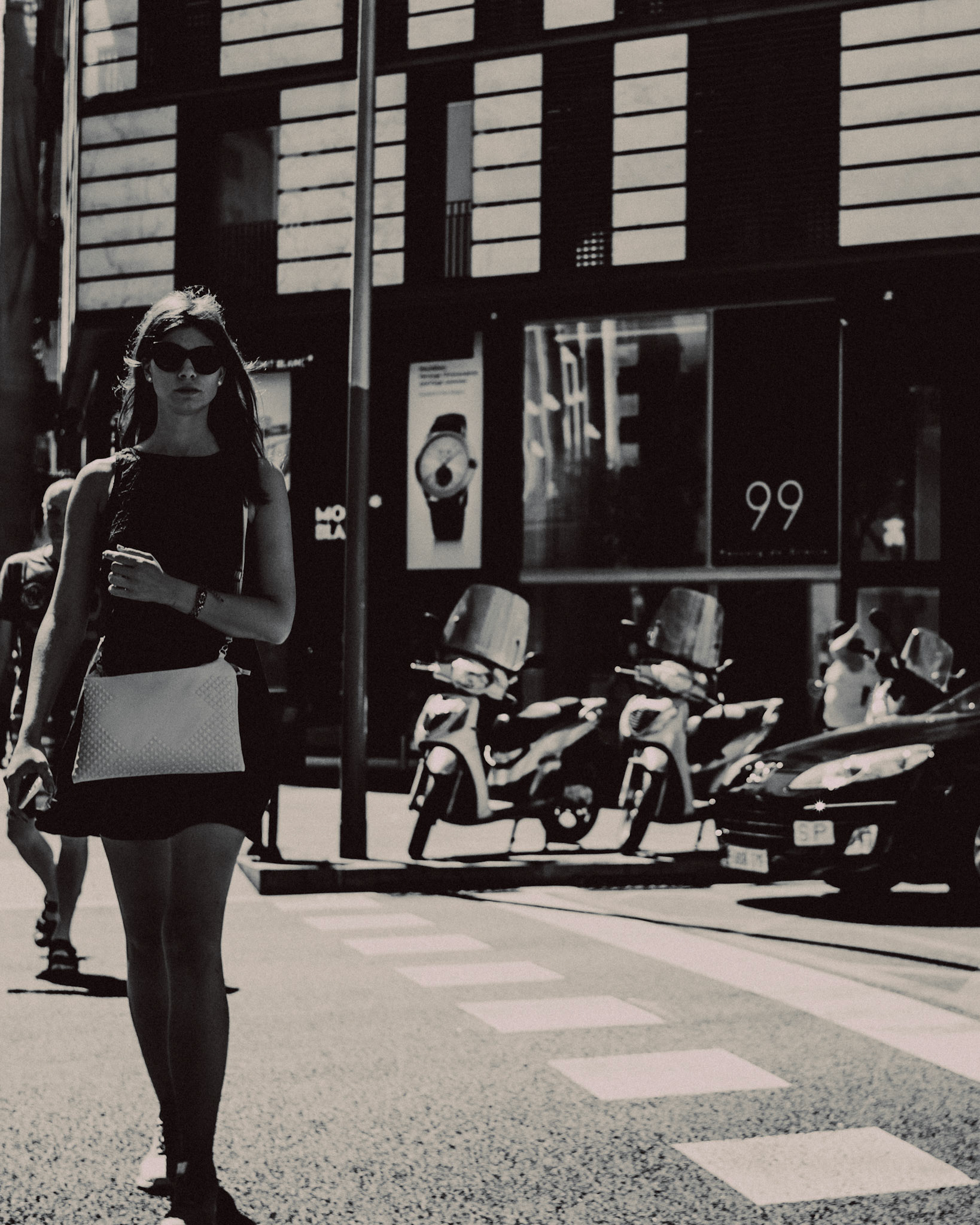 A woman in a black skirt and sunglasses, Passeig de Gracia, Barcelona, Spain, July 2016, Leica M.