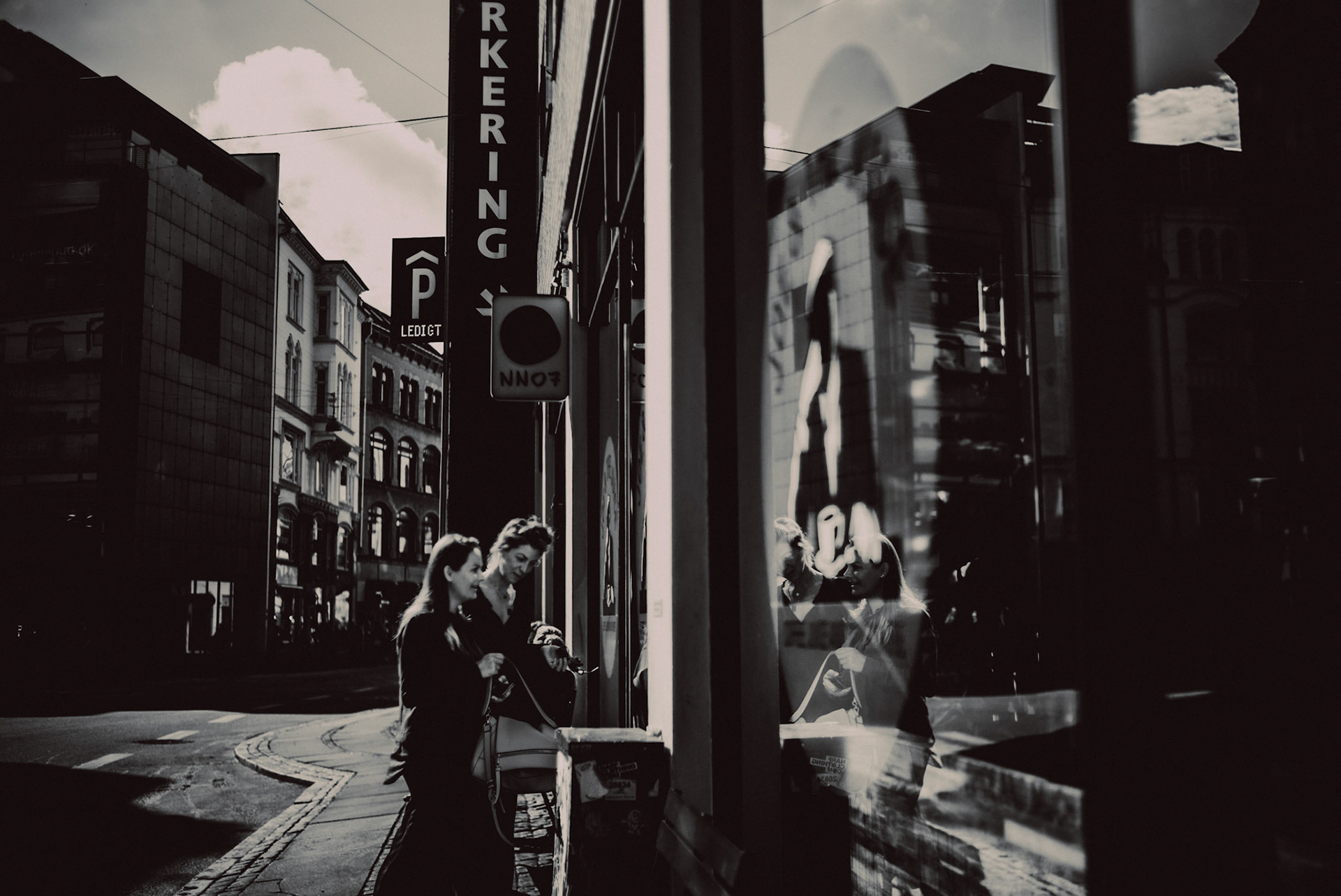 Two women entering Joe &amp; The Juice, in black and white, Copenhagen, Denmark, July 2017, Leica M.