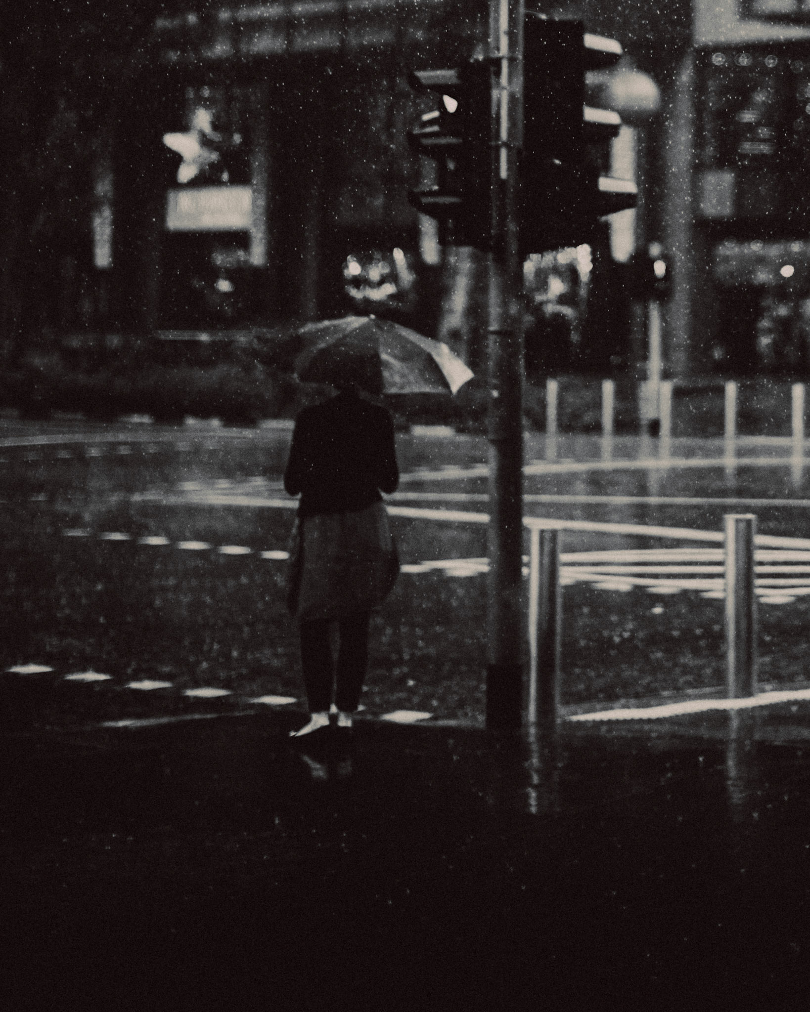 A woman holding an umbrella in the middle of a torrential downpour, in black and white, Orchard Road, Singapore, November 2014, Leica M.