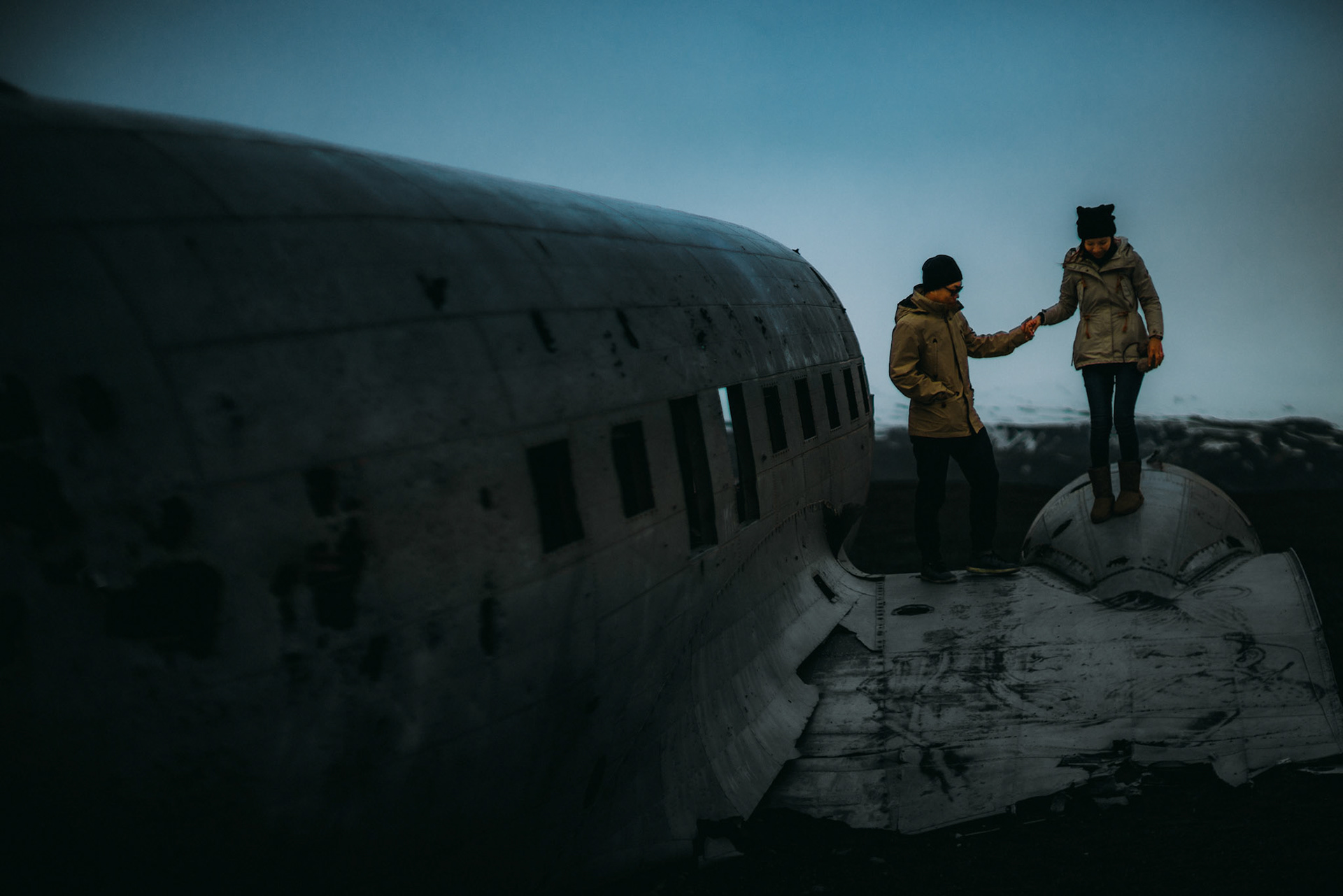 Moody-toned candid adventure engagement portraits at the Sólheimasandur Plane Crash Site, Iceland, May 2016, Sony A7RII.