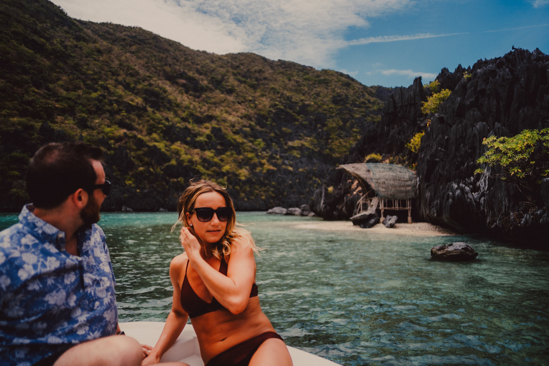 Travel and adventure couple portraits with Skipper Charters, on a cove with a hidden beach with turquoise blue water surrounded by limestone cliffs, Star Beach, Tapiutan Island, El Nido, Palawan, Philippines,Southeast Asia, March 2019, Sony A7III.