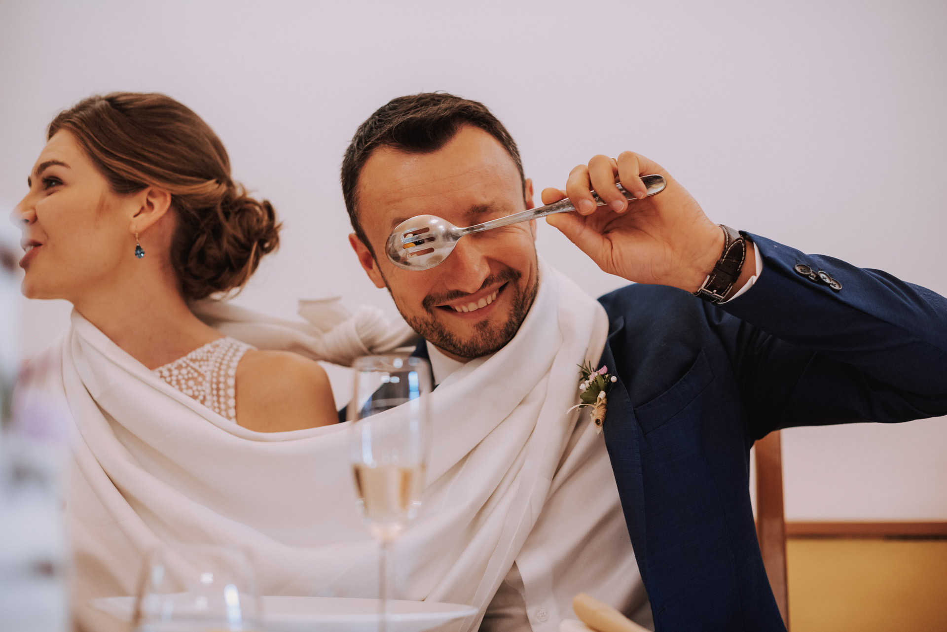 ženich žertovně kouká skrz děravou lžíci na polévku