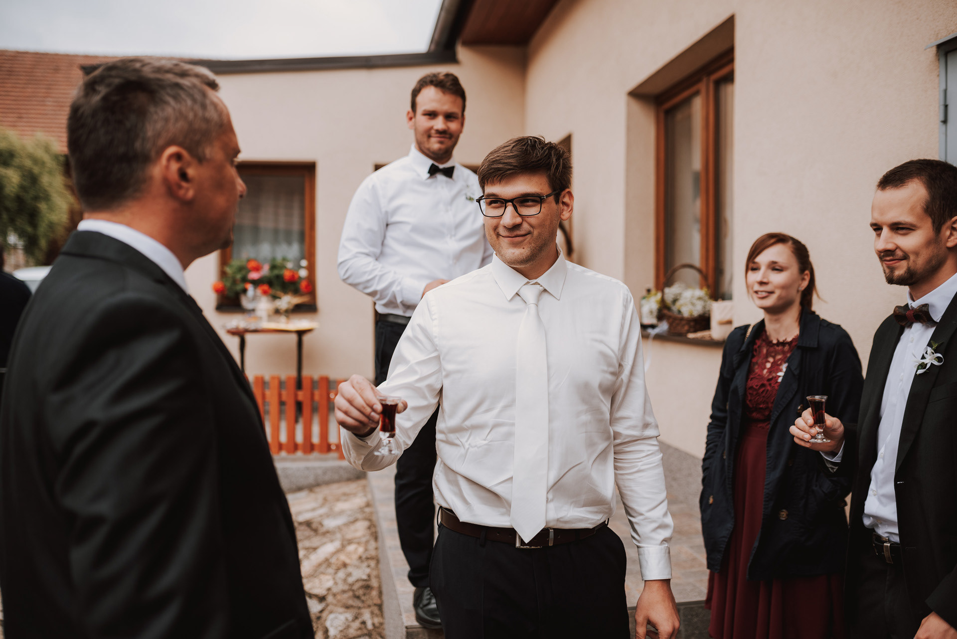 ženich si připíjí s hosty na přivítanou