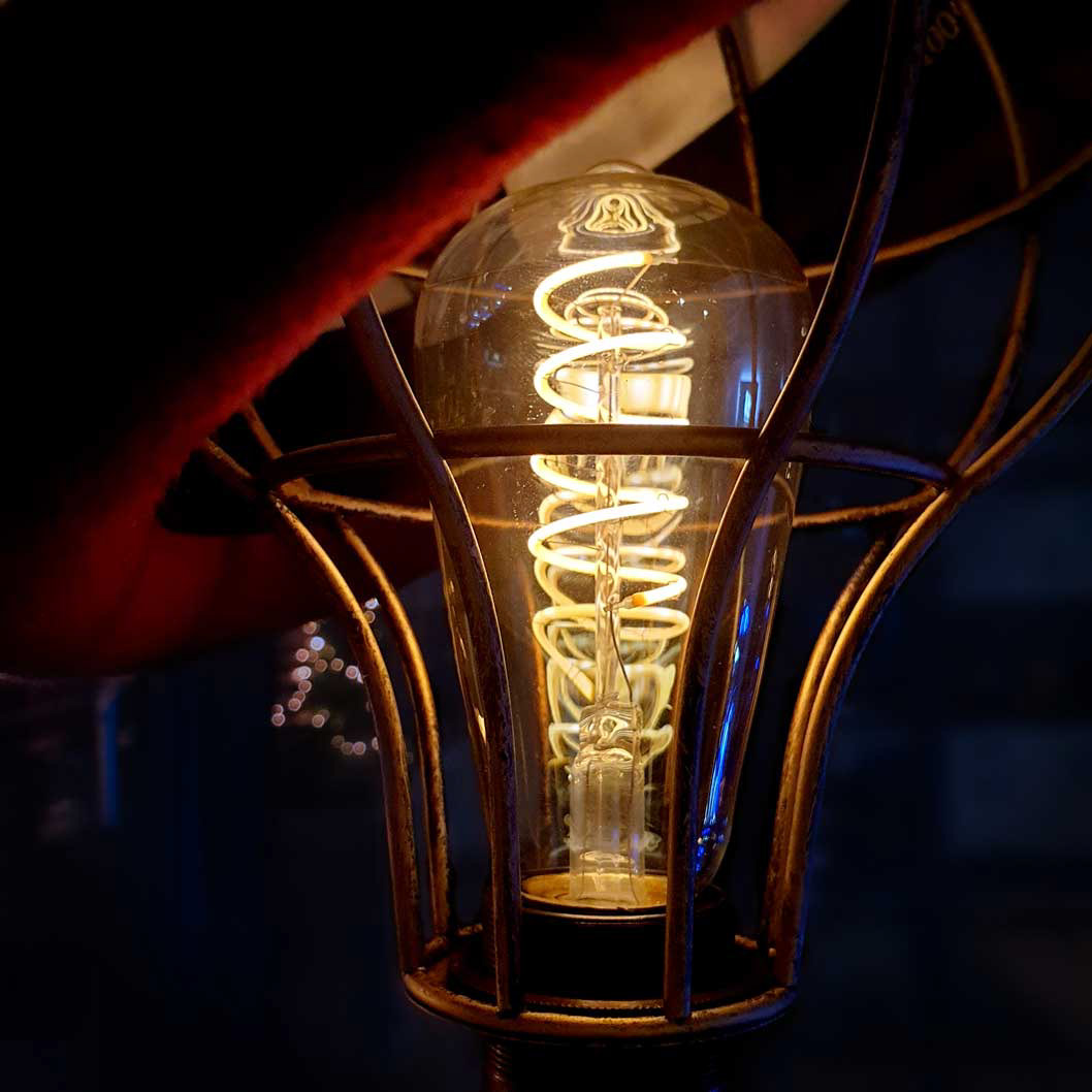 Antique metal style bulb cage with vintage Edison bulb with spiral filament