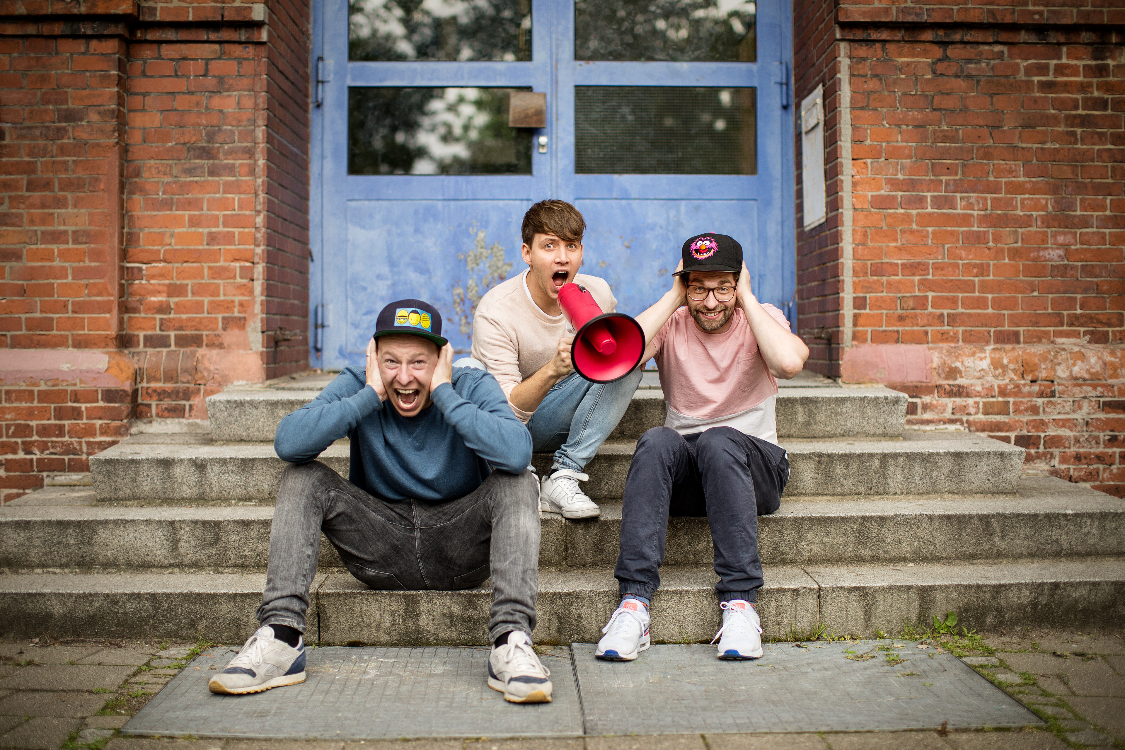 Deine Freunde mit Megaphon vor der Schule