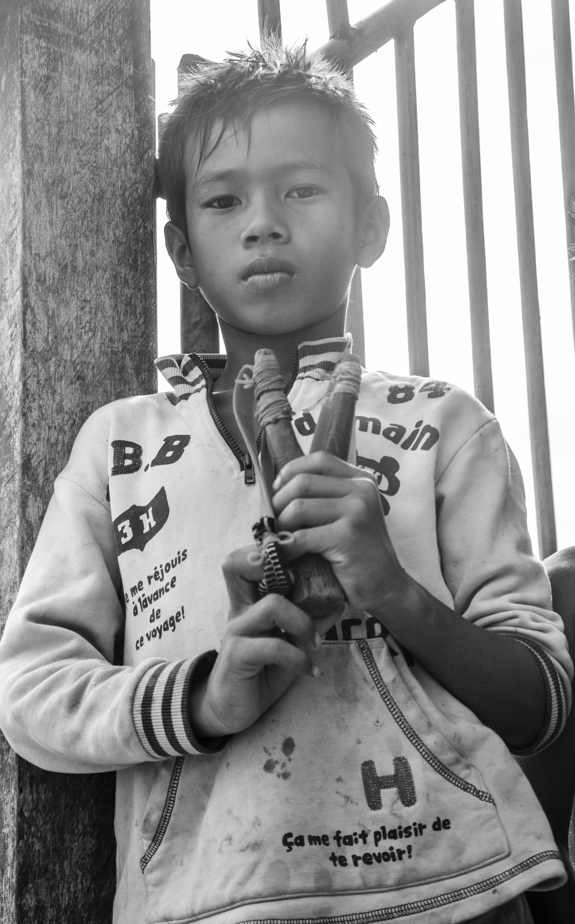 Boy playing with a slingshot, Cambodia
