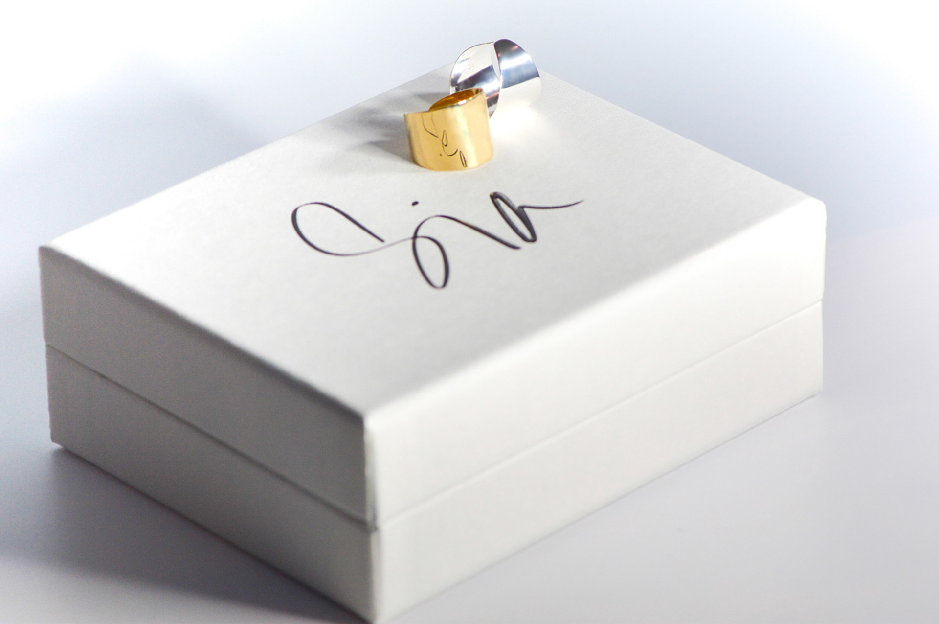 Gold and Silver rings on branded packaging - creative jewellery photography for Sia Shafer