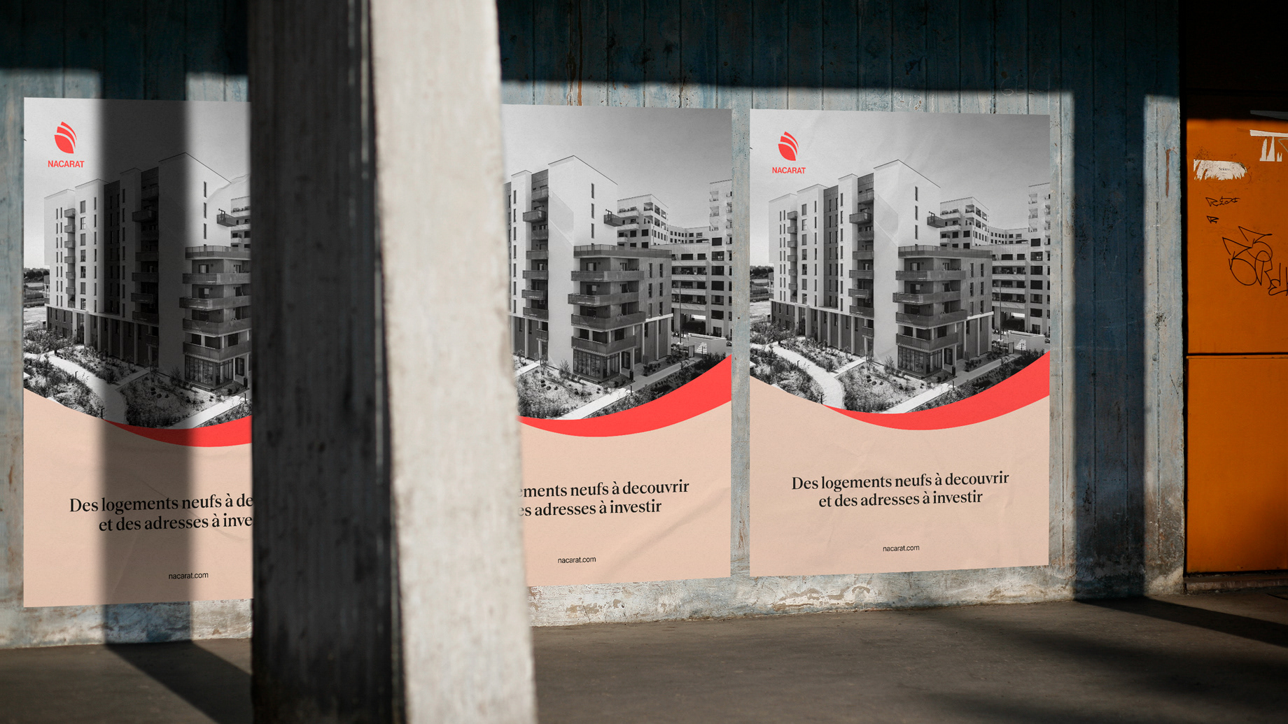 Trois affiches alignées sur un mur en béton dans la rue avec un poteau au premier plan
