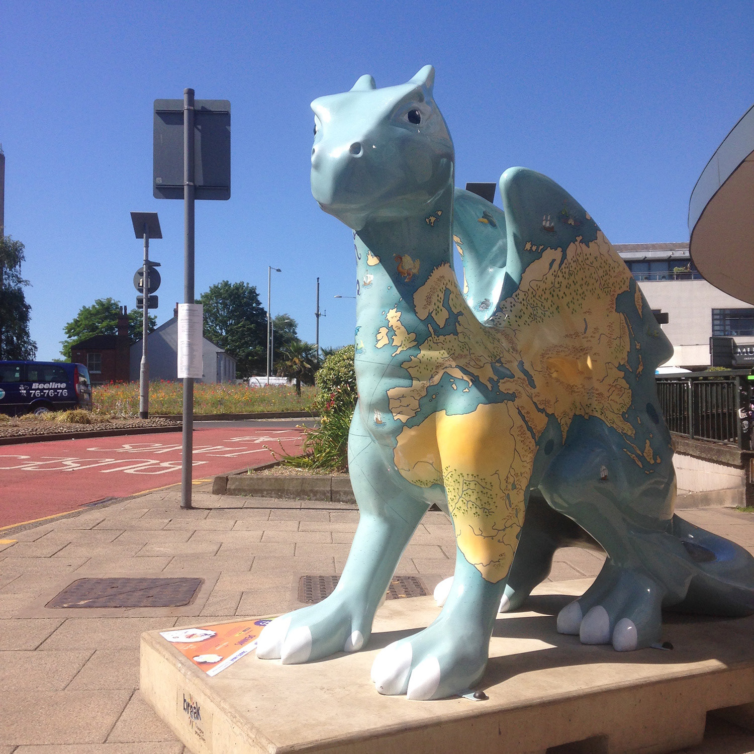 Dragon sculpture painted with an illustrated map of the world populated by sea monsters By Fiona Gowen. Part of the GoGoDragons! Trail in Norwich in 2015