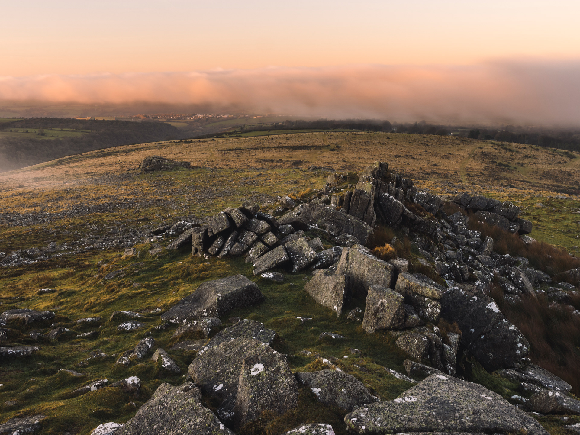 Sunset and fog hanging over Belstone Village and Belstone Tor