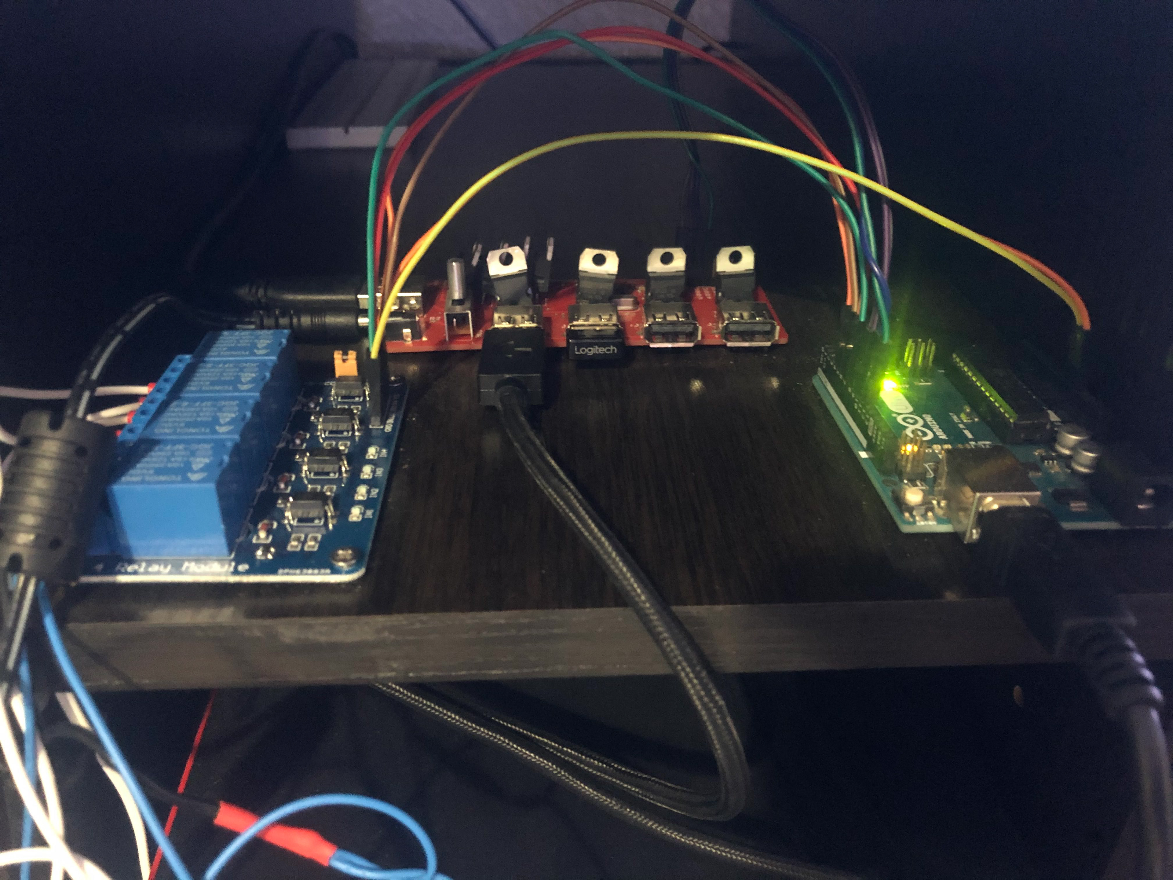 Blue relay board left connected to shock pads, red usb switcher hub, green arduino right