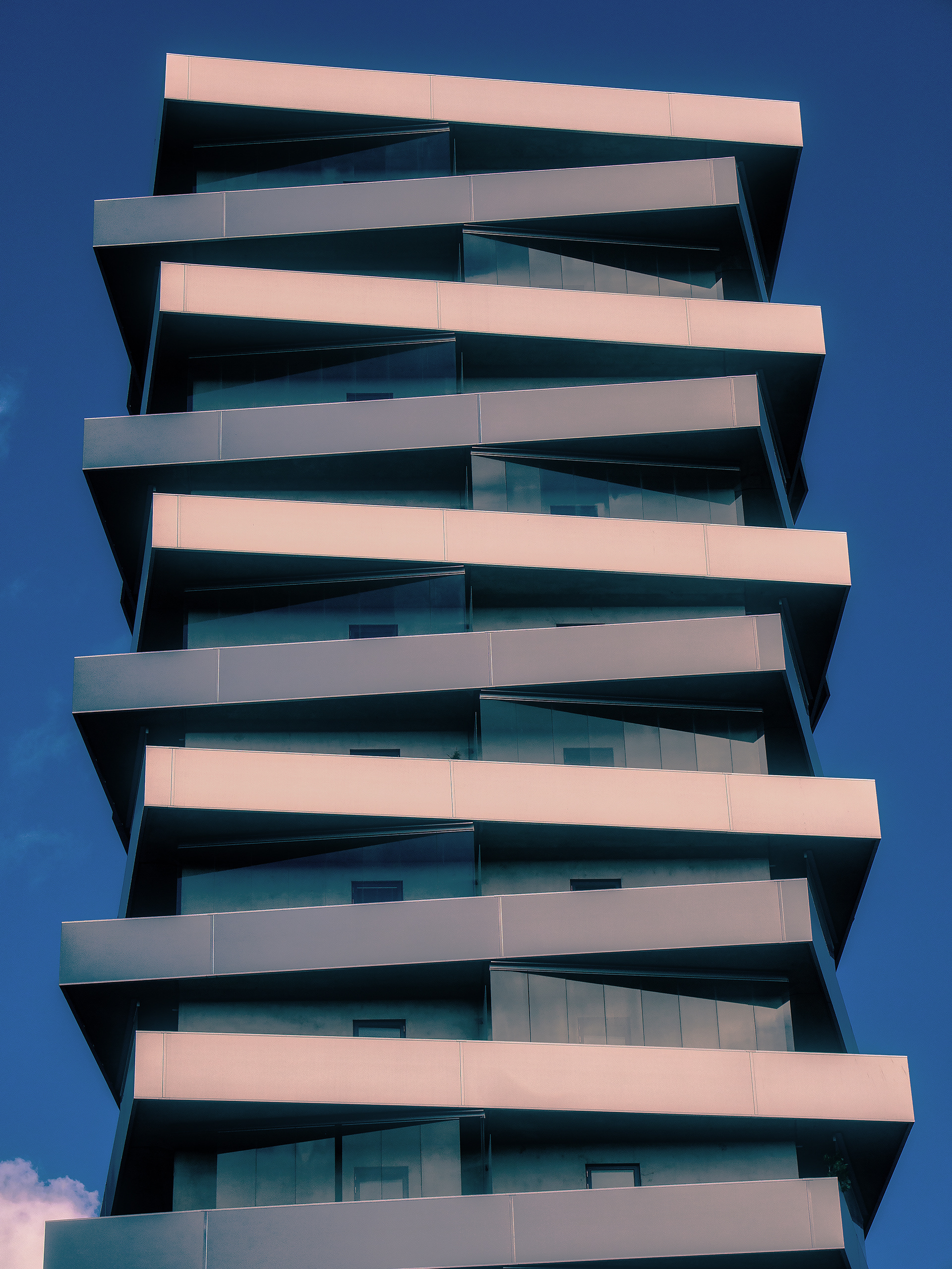 Multi tiered metal facade building against a blue sky