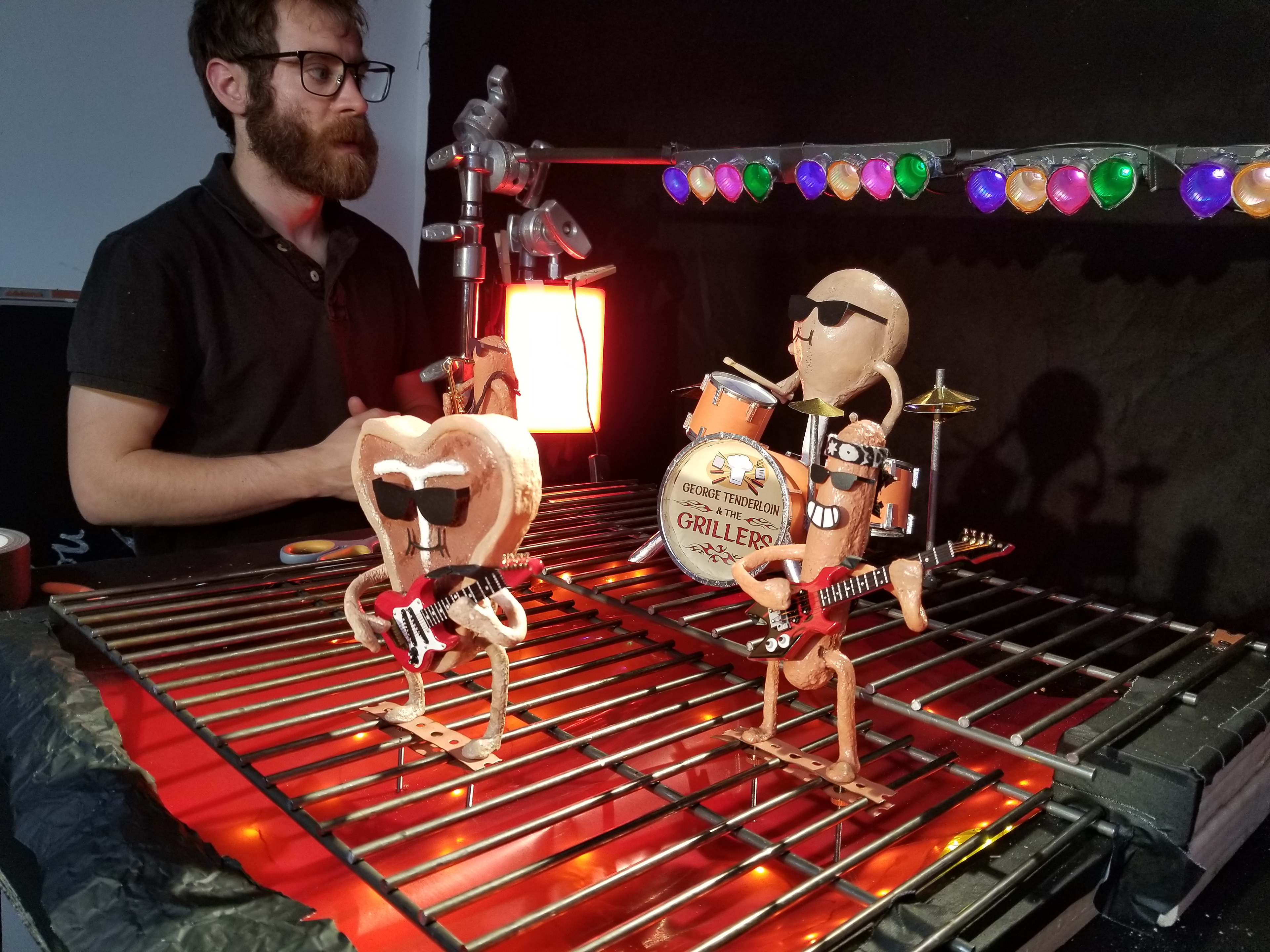We used coffee creamers and colored gels to make the practical stage lighting. There are also LED string lights under a gel combo beneath the grid to simulate hot coals.