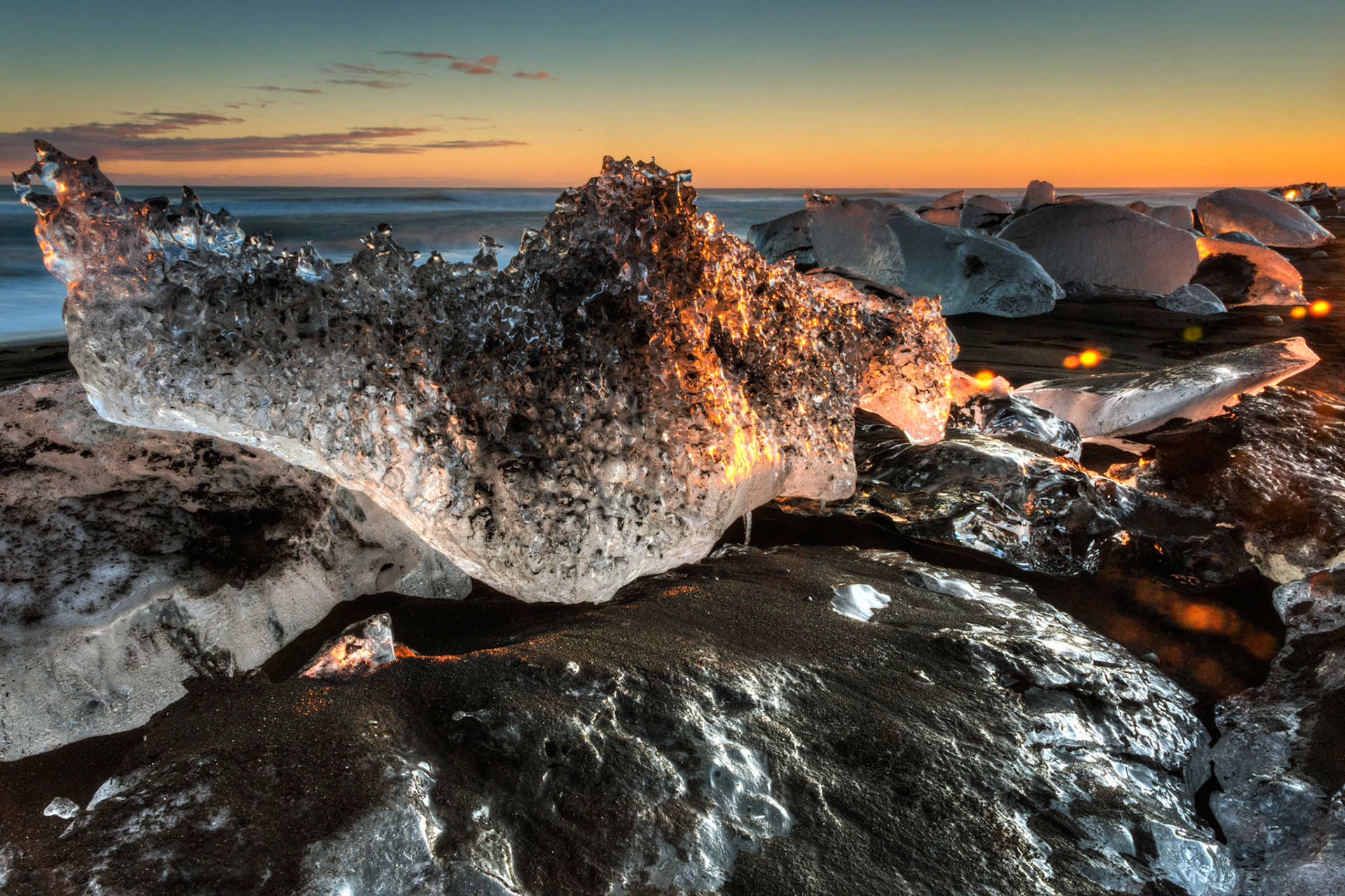 Ice boulders on the black sand beach near Jökulsárlón, at sunset.Austurland, IcelandFebruary 9, 2016This is an HDR image consisting of 5 exposures merged in Photomatix Pro. Additional processing in Lightroom and Photoshop.PENTAX K-3, Sigma 18-250mm f/3.5-6.3 DC OS HSMISO 100 18 mm  2.0 sec at ƒ / 20