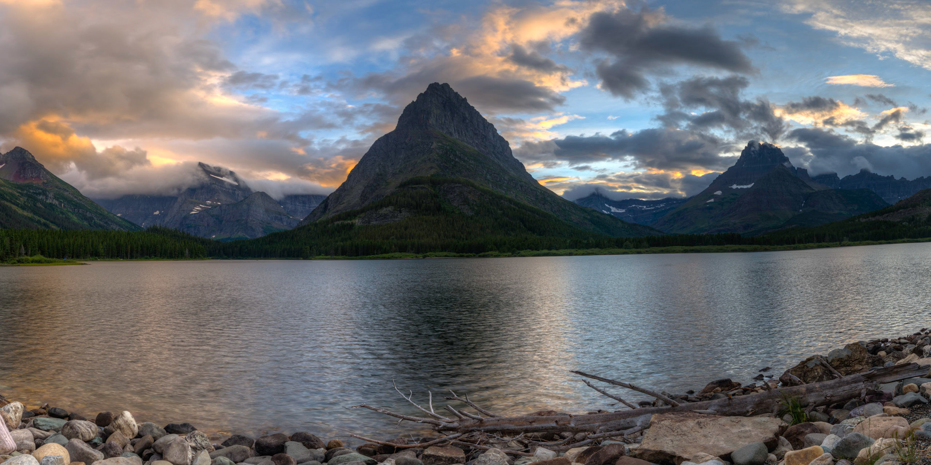 Sunset at Swiftcurrent Lake, right outside of the Many Glacier Hotel.Glacier National ParkJuly 27, 2015This is an HDR panoramic image consisting of 7 frames comprised of 5 exposures each. HDR processing performed in Photomatix Pro.  Panoramic stitching performed in Photoshop. Additional processing performed in Lightroom and Photoshop.PENTAX K-3, Sigma 10-20mm f/4-5.6 EX DCISO 100 20 mm  ⅛ sec at ƒ / 11