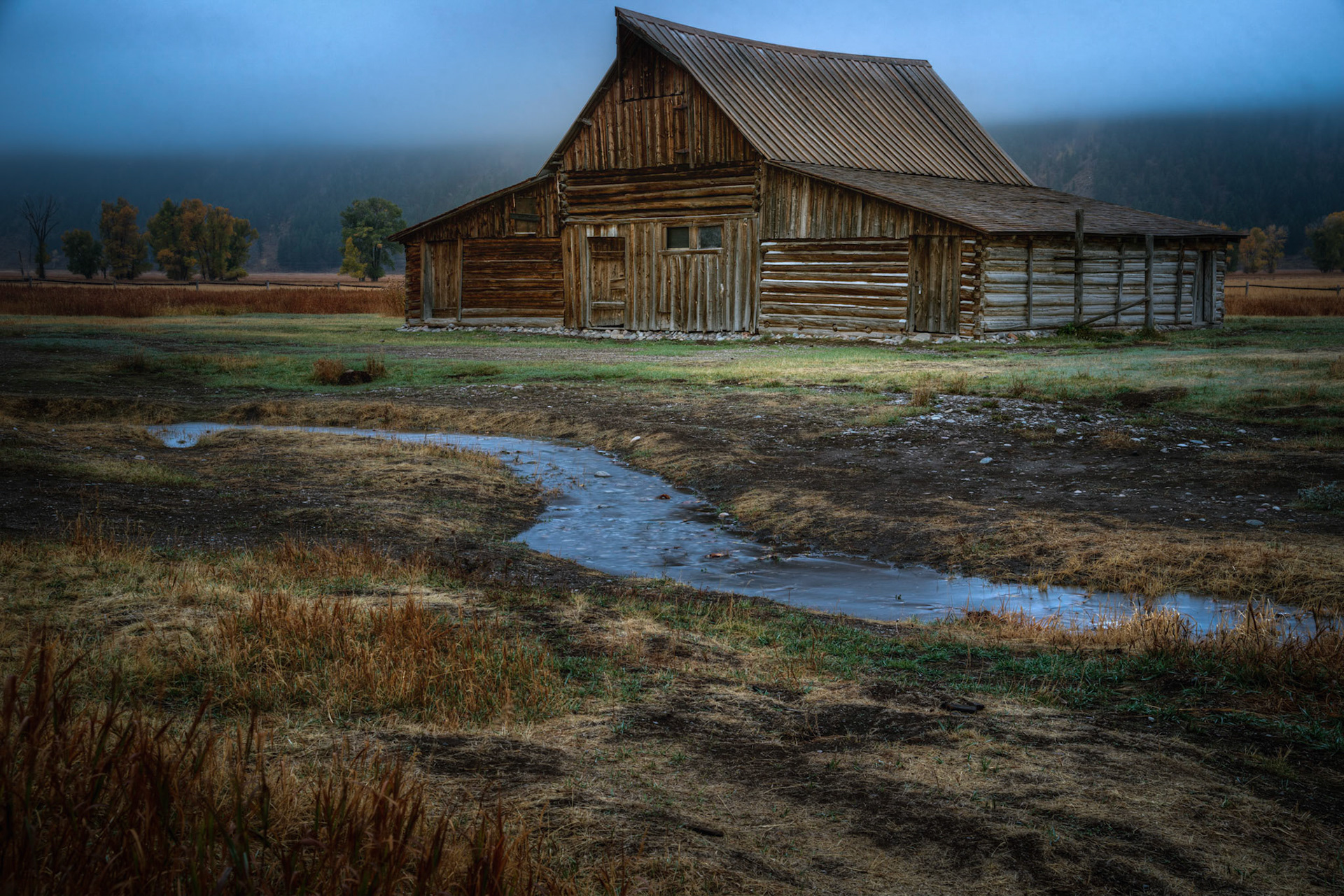 A foggy autumn dawn in Jackson Hole, along Mormon Row.Grand Teton National ParkWyomingSeptember 30, 2016This is an HDR image consisting of 3 exposures merged in Photomatix Pro. Additional processing in Lightroom and Photoshop.PENTAX K-1, TAMRON 28-300mm F3.5-6.3 Ultra zoom XRISO 100 53 mm  15.0 sec at ƒ / 11