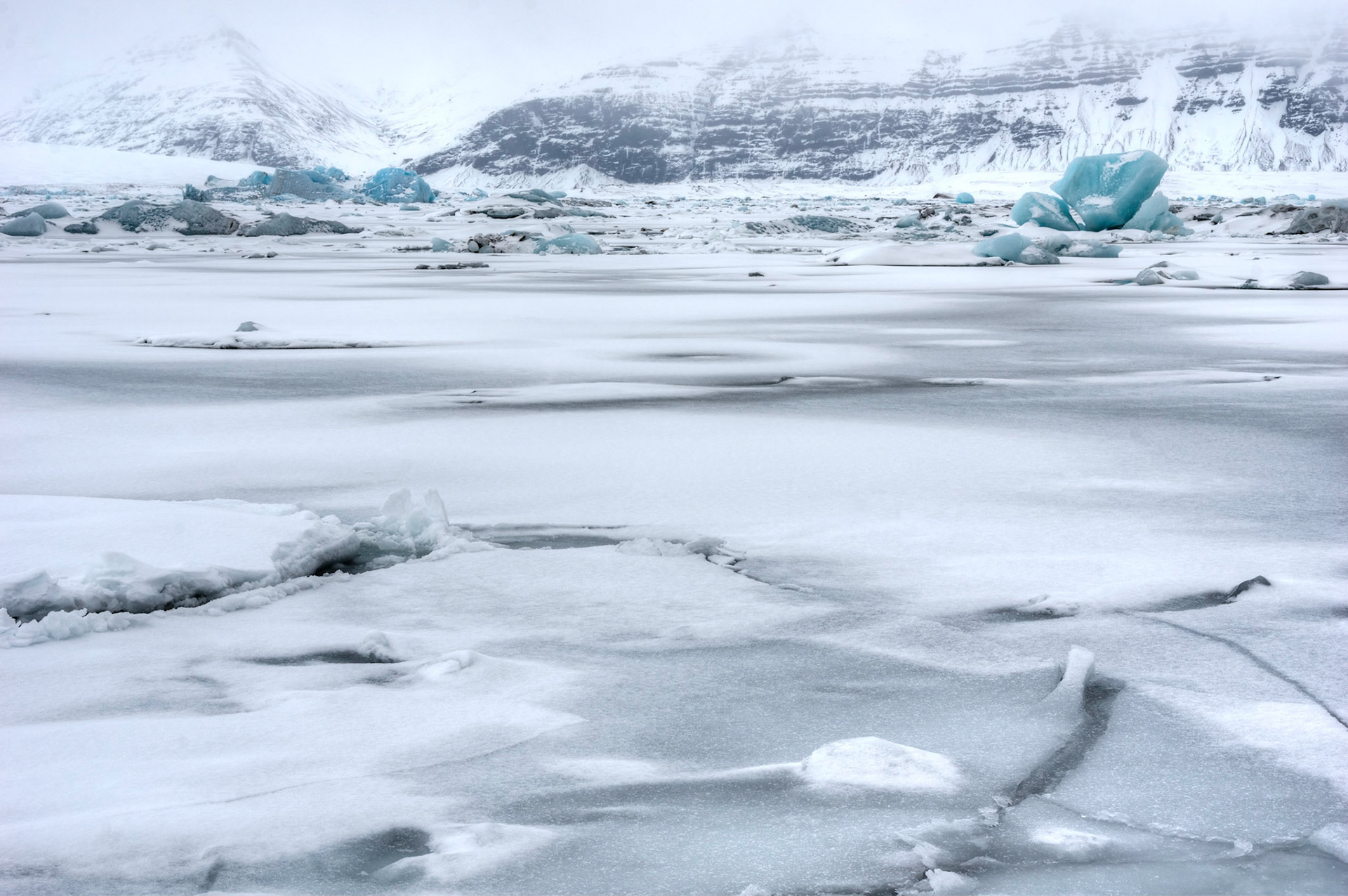 Fresh snow on the ice of the glacial lagoon of Jökulsárlón, against the backdrop of Fellsfjall.JökulsárlónAusturland, IcelandFebruary 10, 2016This is an HDR image consisting of 3 exposures merged in Photomatix Pro. Additional processing in Lightroom and Photoshop.PENTAX K-3, Sigma 18-250mm f/3.5-6.3 DC OS HSMISO 100 45 mm  ¹⁄₁₃ sec at ƒ / 13
