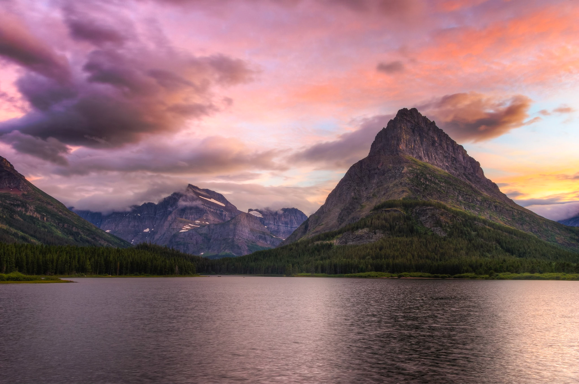 Sunset at Swiftcurrent Lake, with the backdrop of Mt. Gould, Angel Wing, and Grinnell Point.Glacier National ParkJuly 27, 2015This is an HDR image consisting of 5 exposures merged in Photomatix Pro. Additional processing in Lightroom and Photoshop.PENTAX K-3, Sigma 18-250mm f/3.5-6.3 DC OS HSMISO 100 18 mm  ⅛ sec at ƒ / 11
