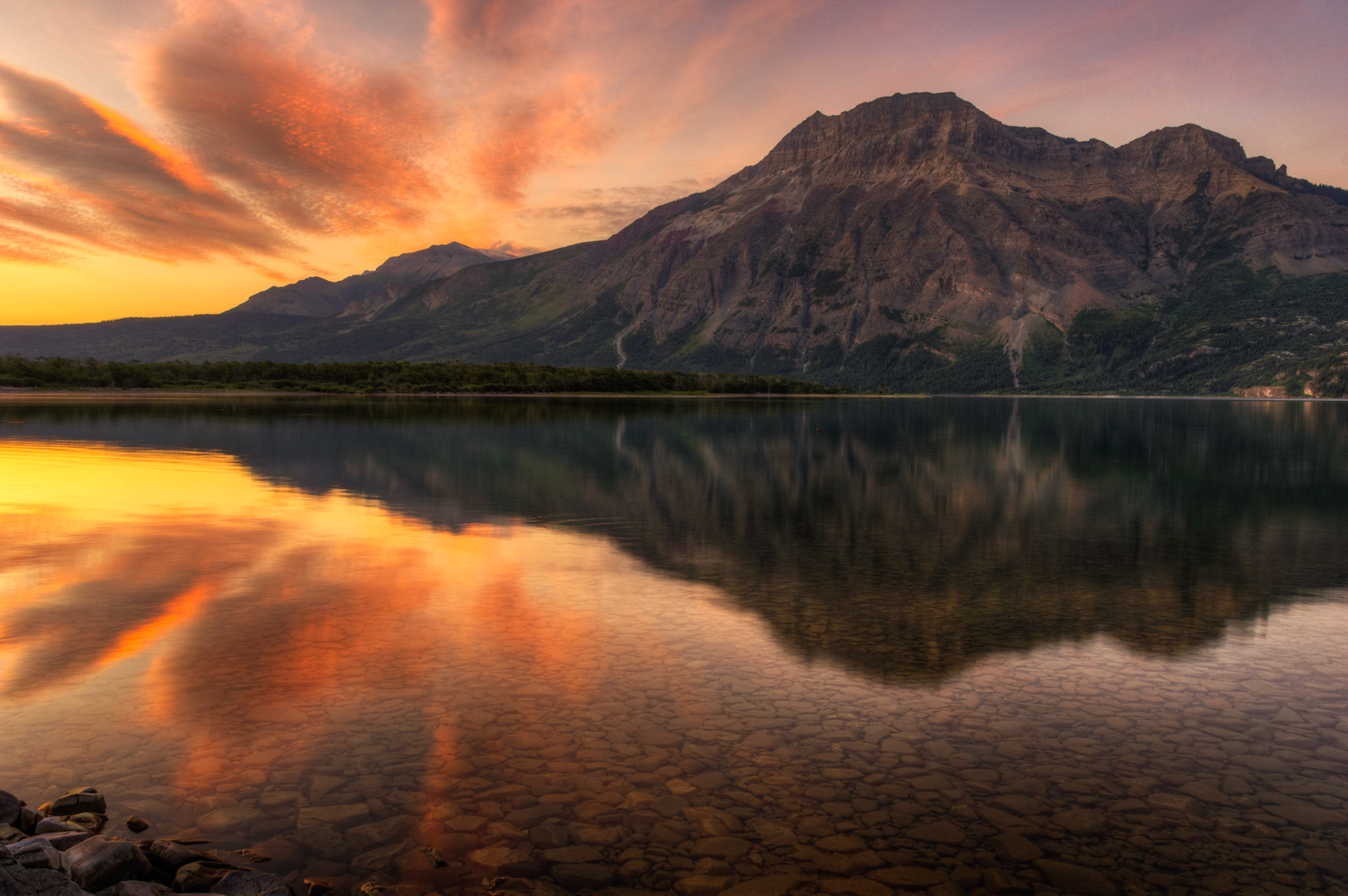 Sunrise over Middle Waterton Lake, looking towards Vimy Peak.Waterton Lakes National ParkAugust 2, 2015This is an HDR image consisting of 5 exposures merged in Photomatix Pro. Additional processing in Lightroom and Photoshop.PENTAX K-3, Sigma 18-250mm f/3.5-6.3 DC OS HSMISO 100 18 mm  0.5 sec at ƒ / 11