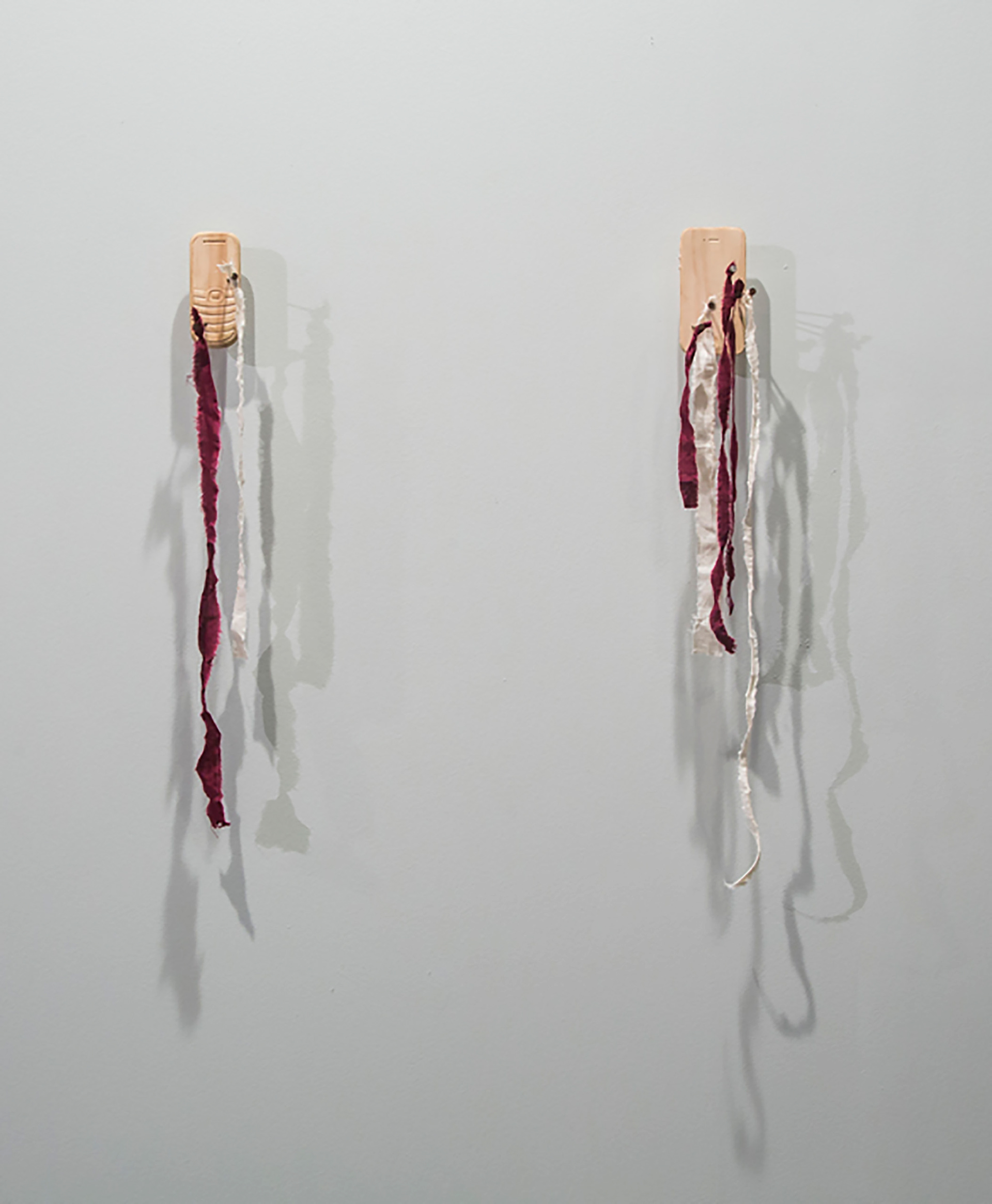 Ex-Votos: Samsung E1207T and iPhone 4 - carved pine, cloth nails