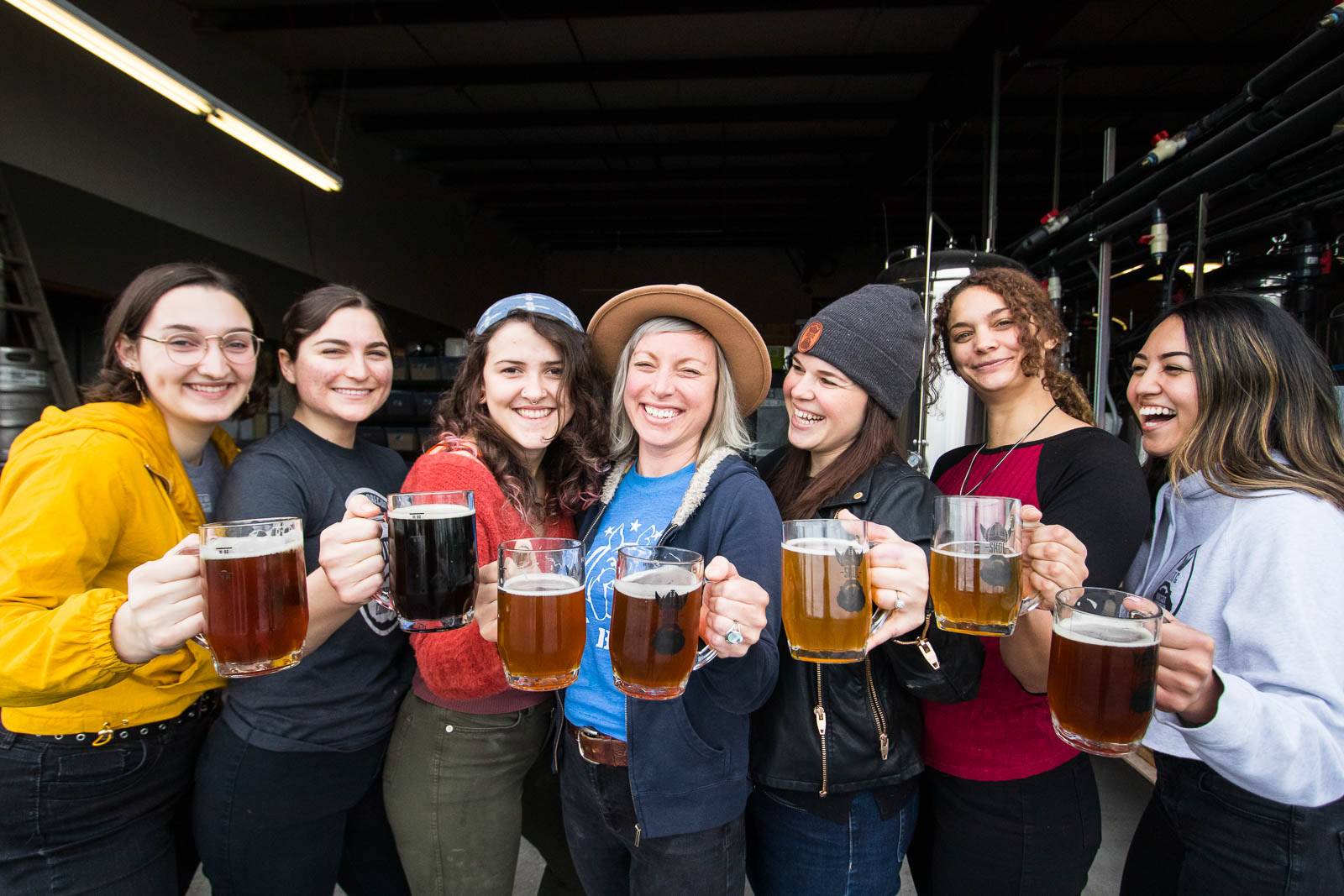 The women of Viking Braggot Company all hold beers up to cheers