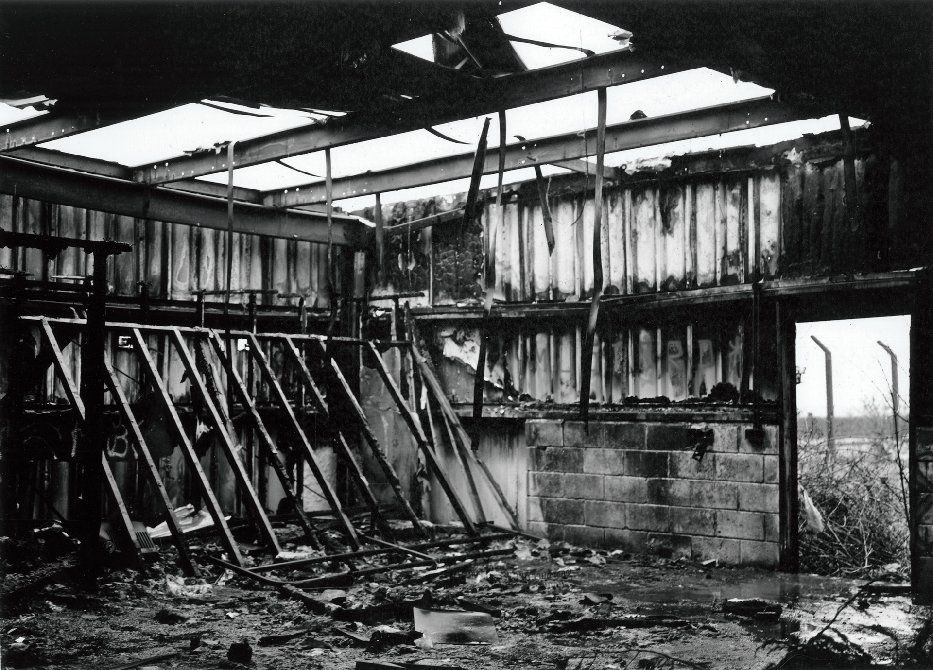 a burnt out room of some industrial space. The roof has caved in due to the damage