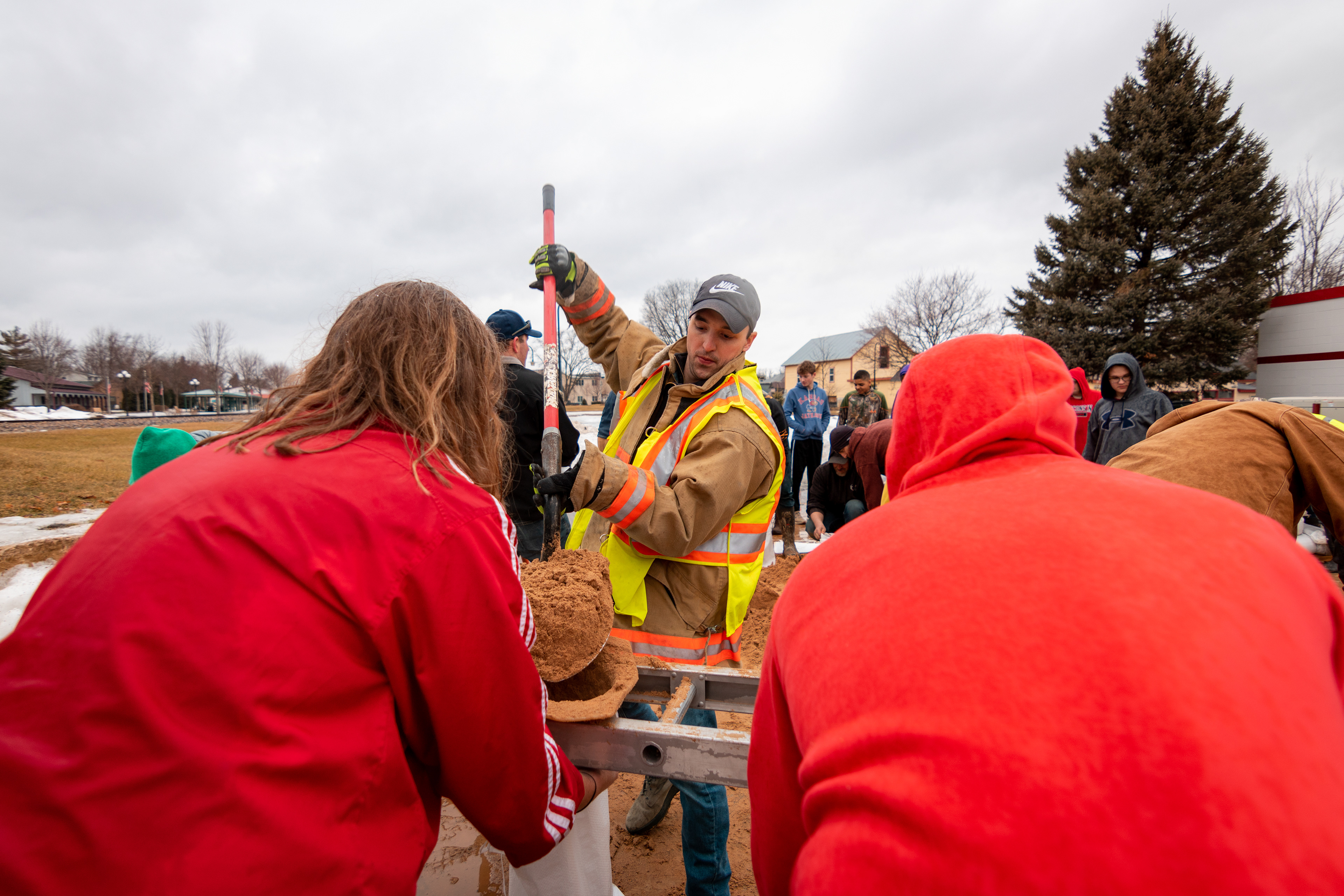 Several Mazomanie residents volunteer their time to fill sandbags as quickly melting snow floods backyards and overflows the Black Earth Creek.