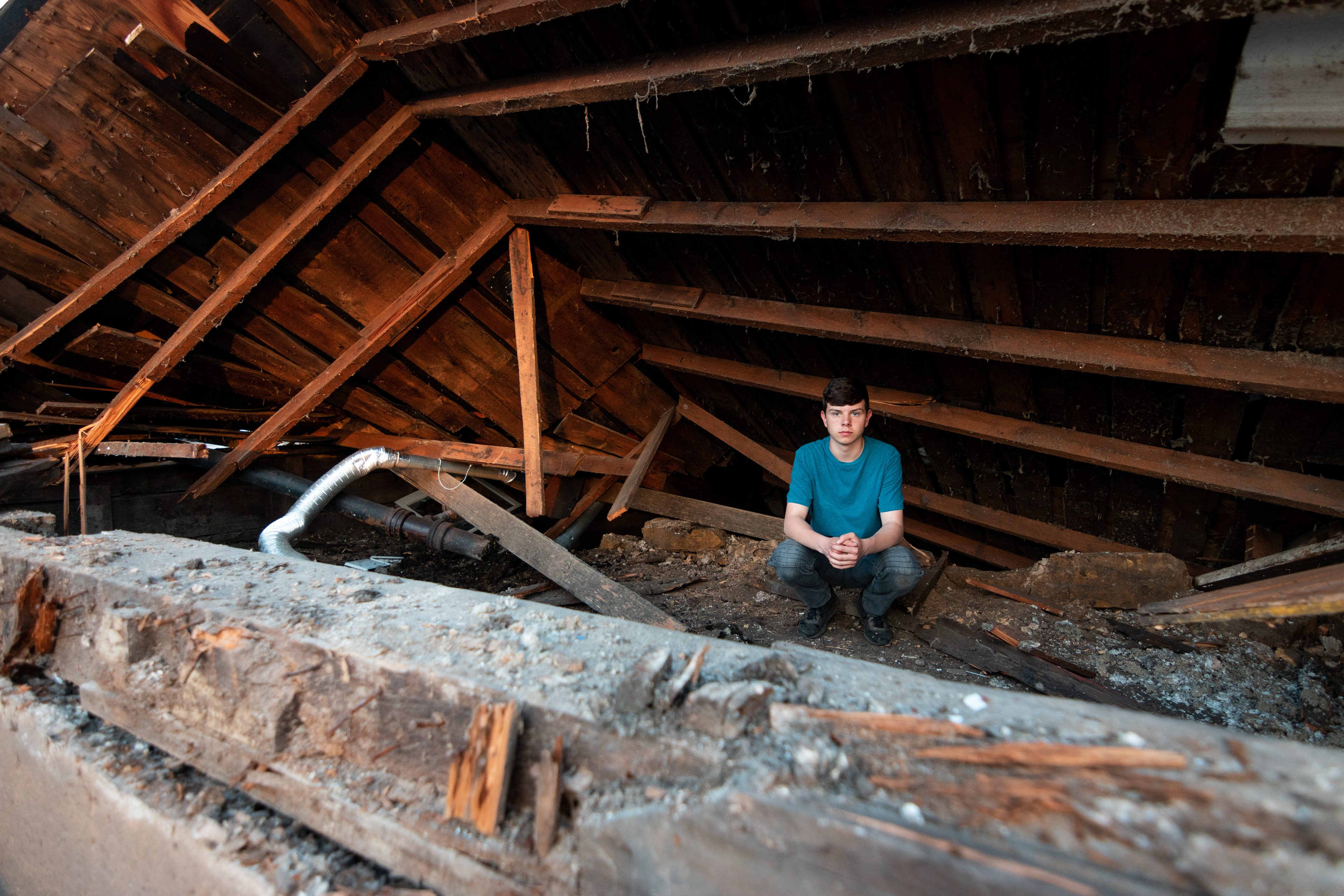 Mitchell Travis takes a self portrait in the remains of his home.