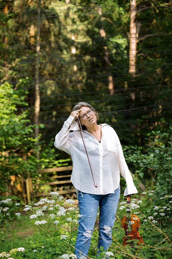 woman portrait, outdoor in the woods. musician with violine