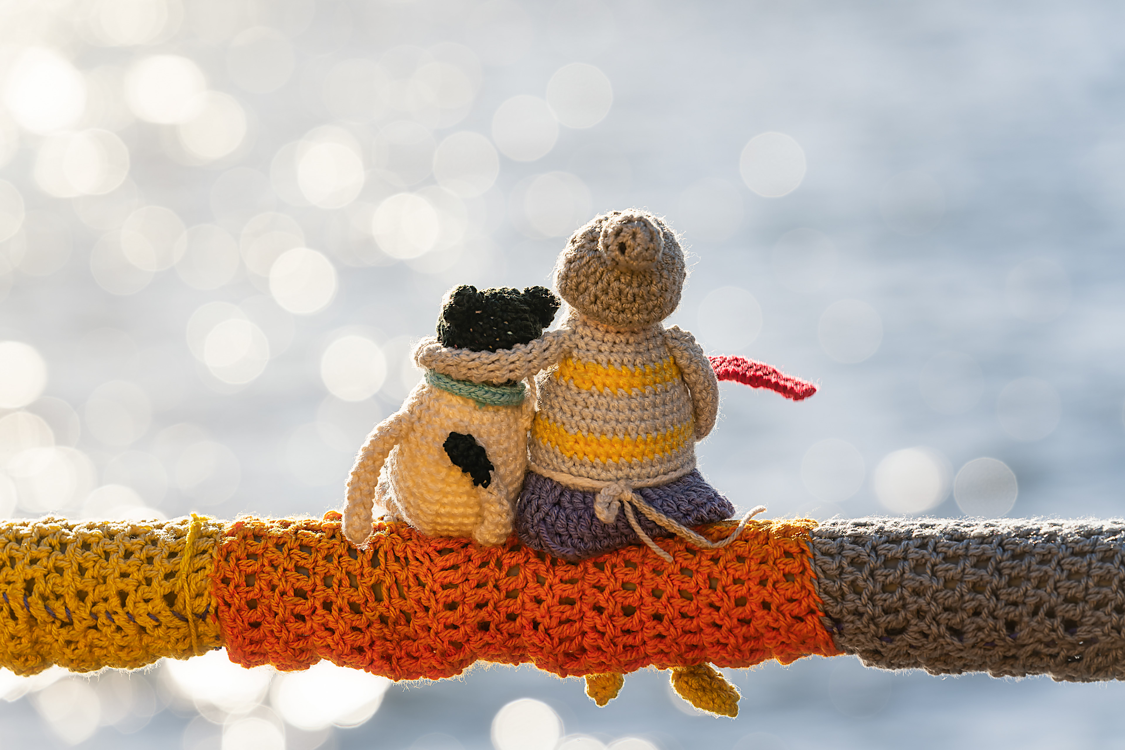 Toy couple snuggle together on the seashore