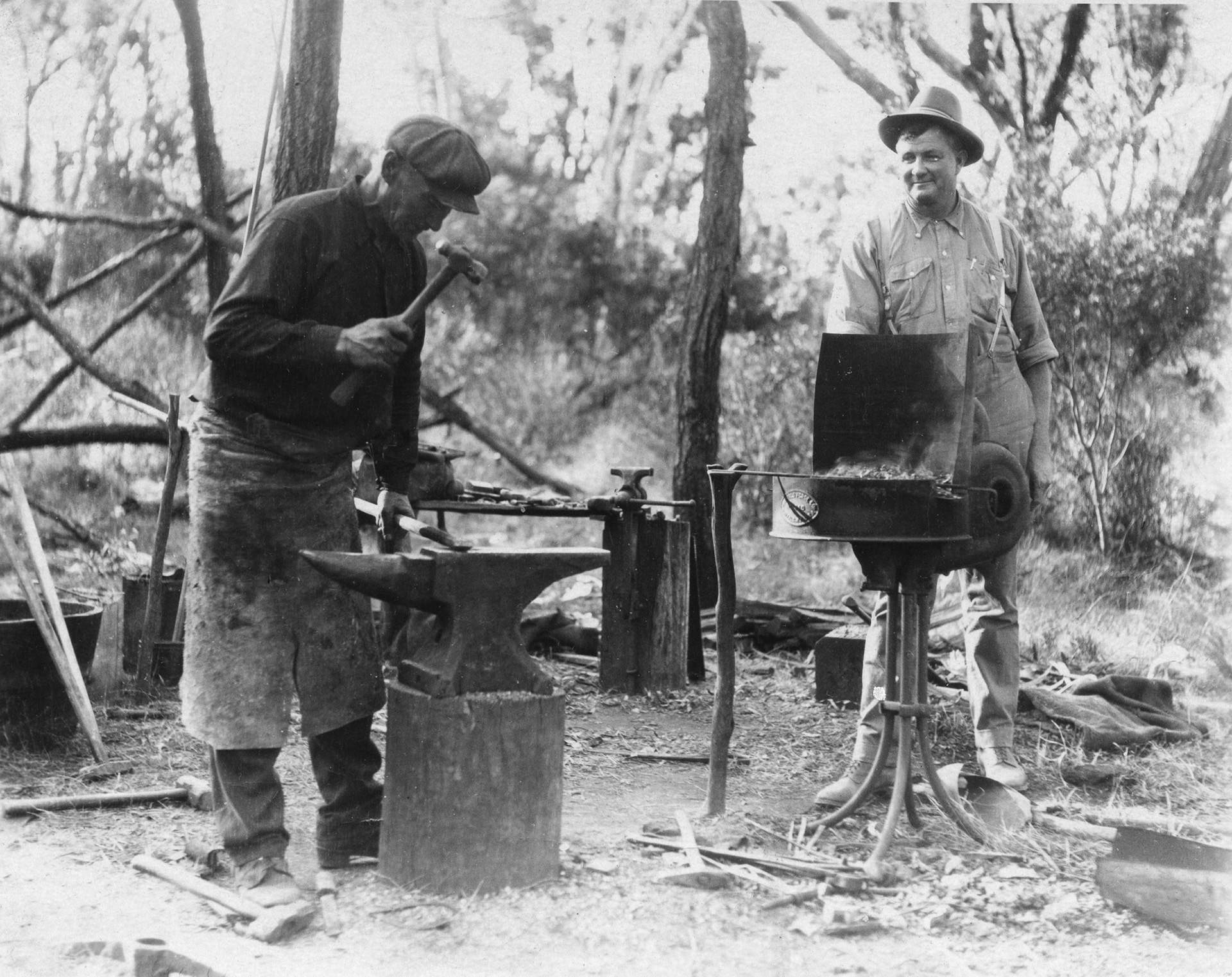 Blacksmith working steel on an anvil at a camp sight
