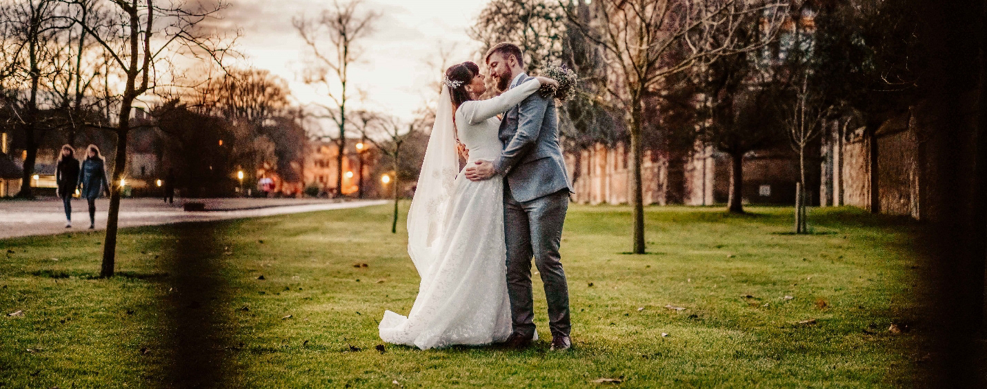 married couple holding each other in intimate golden hour photo near oxford town hall after covid wedding with david lefebvre