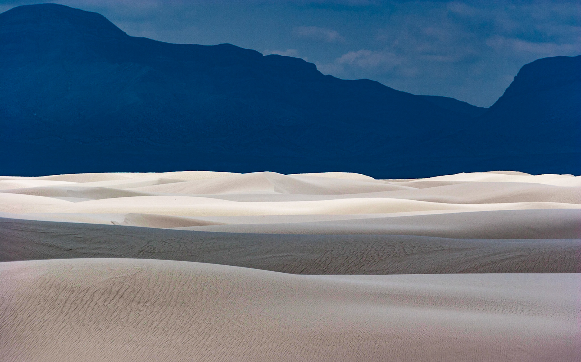 White Sands National Monument, New Mexico. Rising from the heart of the Tularosa Basin is one of the world's great natural wonders - the glistening white sands of New Mexico. Great wave-like dunes of gypsum sand have engulfed 275 square miles of desert, creating the world's largest gypsum dunefield. White Sands National Monument preserves a major portion of this unique dunefield, along with the plants and animals that live here.