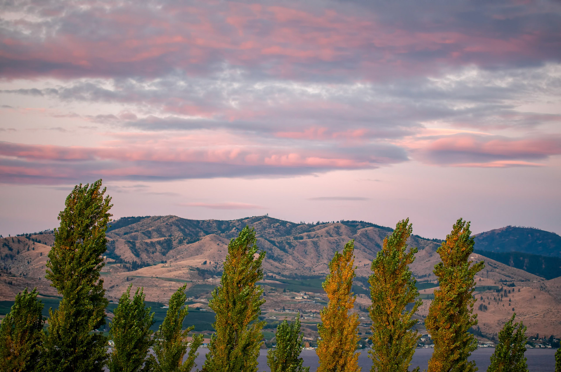 The view of the mountains and hills surrounding Lake Chelan Washington at dawn.