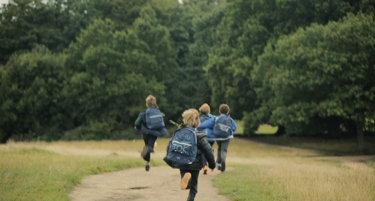 Boys running down the hill in the park