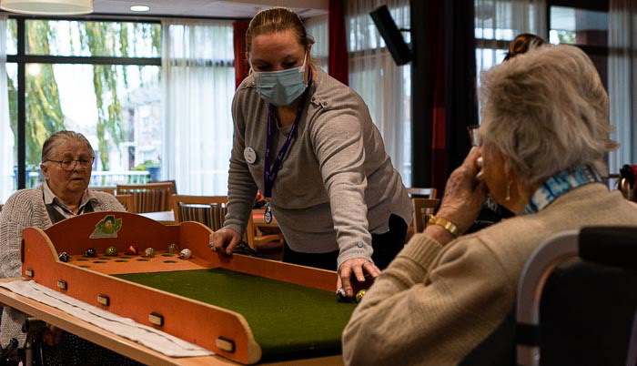 Kelly Veenis (31) helpt bewoners tijdens de spelletjesmiddag in woonzorgcentrum Graafzicht.