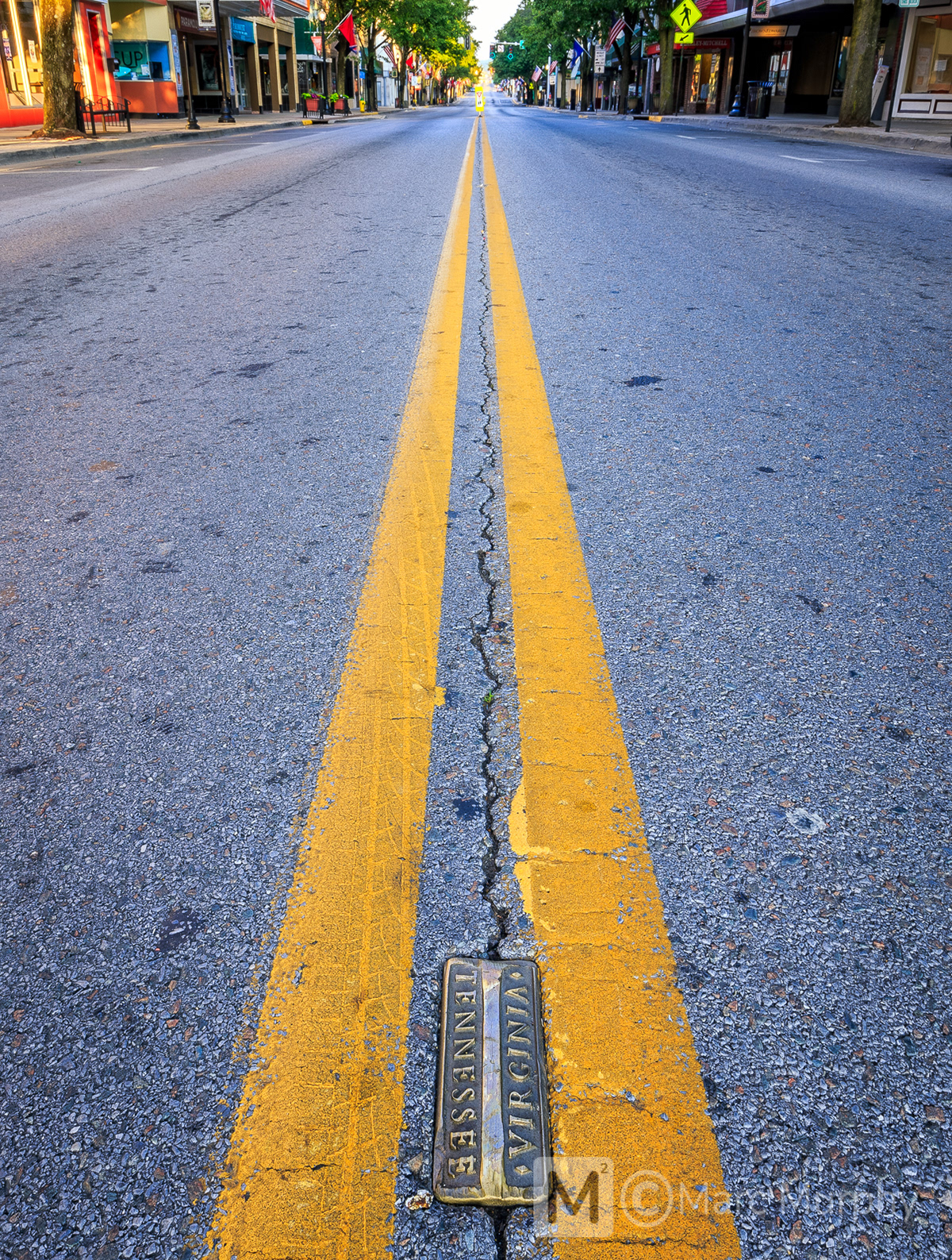 State Street in Downtown Bristol with Gold Tennessee-Virginia Brick and Double Yellow Lines in the Middle of the Street at Sunrise