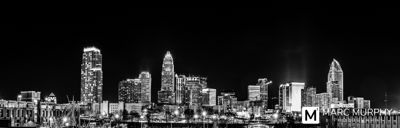 Black and White Charlotte North Carolina Skyline at Night with Sunbursts from Building and Street Lights