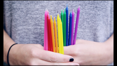 Imagem em close de duas mãos segurando vários lápis coloridos