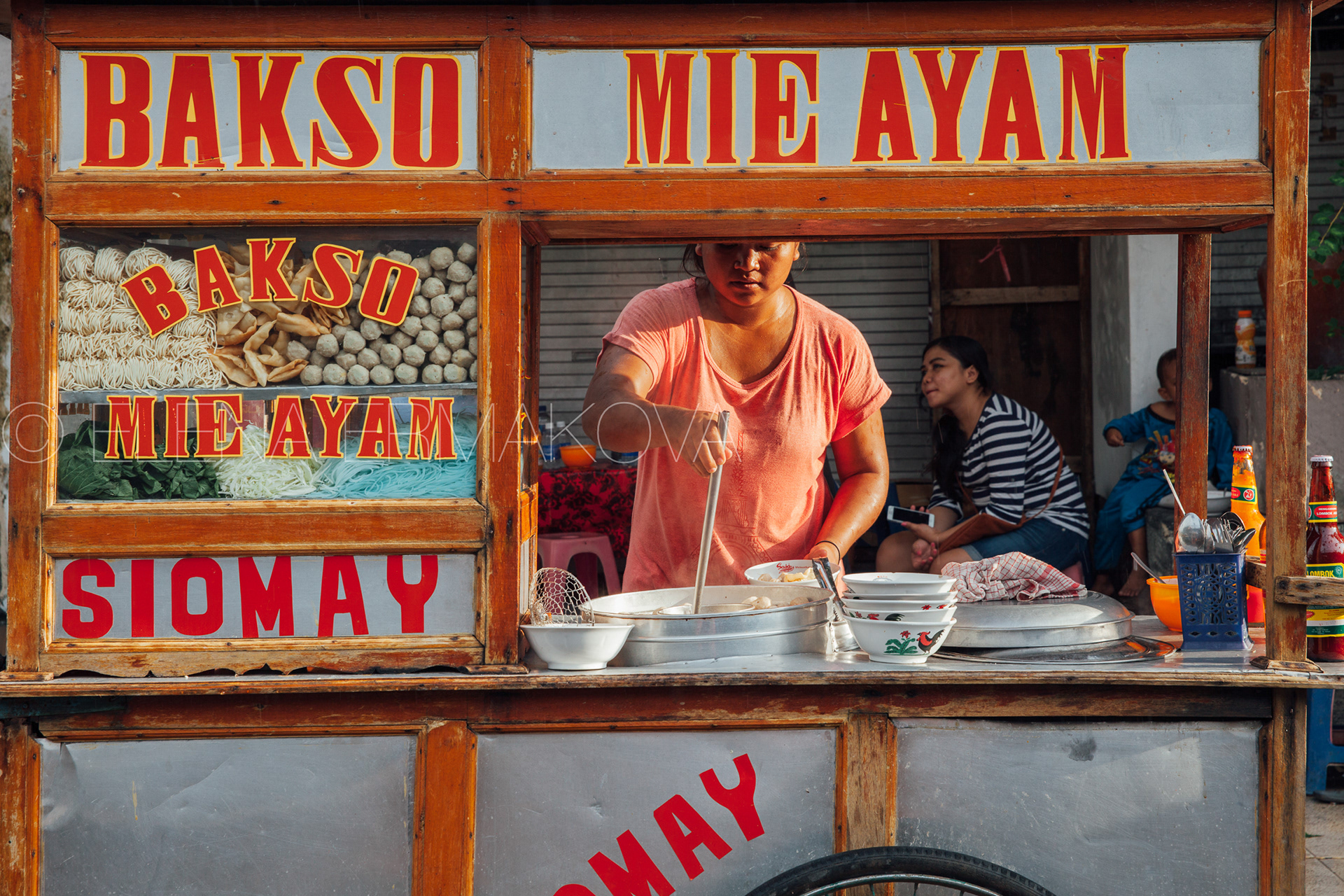 Woman cooks meatball soup at the street stall in Kuta, Bali, Indonesia. Travel photography by Elena Ermakova.